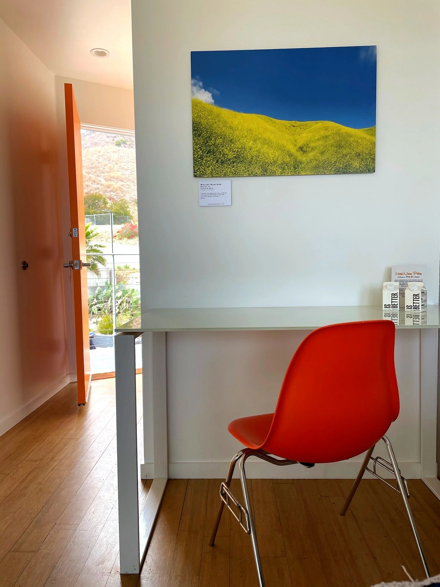 Room desk with Malibu mustard hills art and orange chair at The Malibu Motel, Malibu California