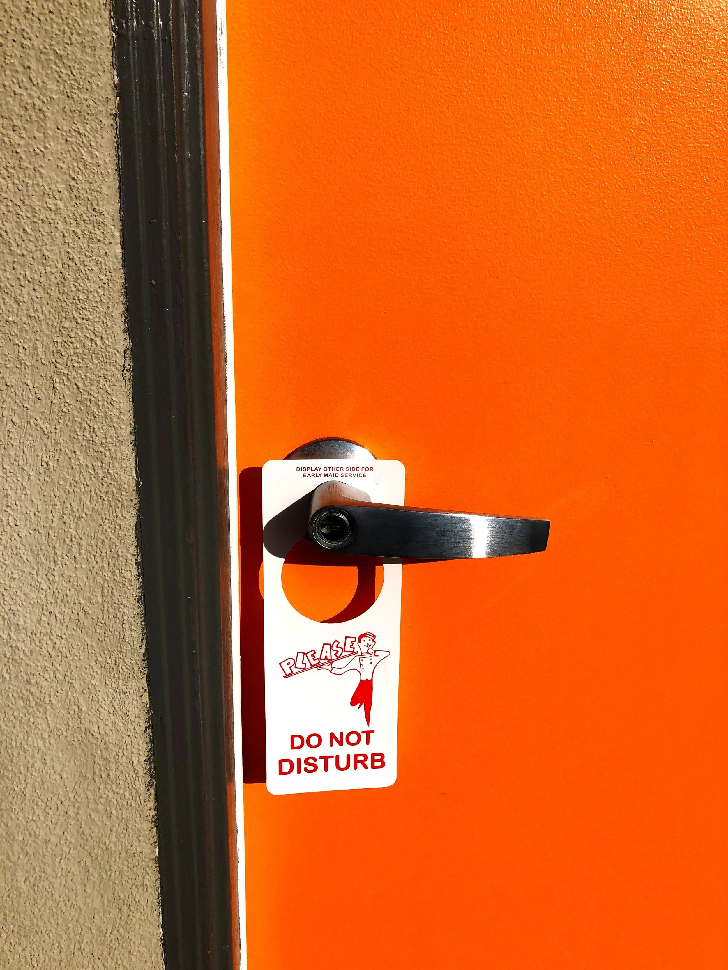 Iconic orange door with do not disturb sign at The Malibu Motel, Malibu California