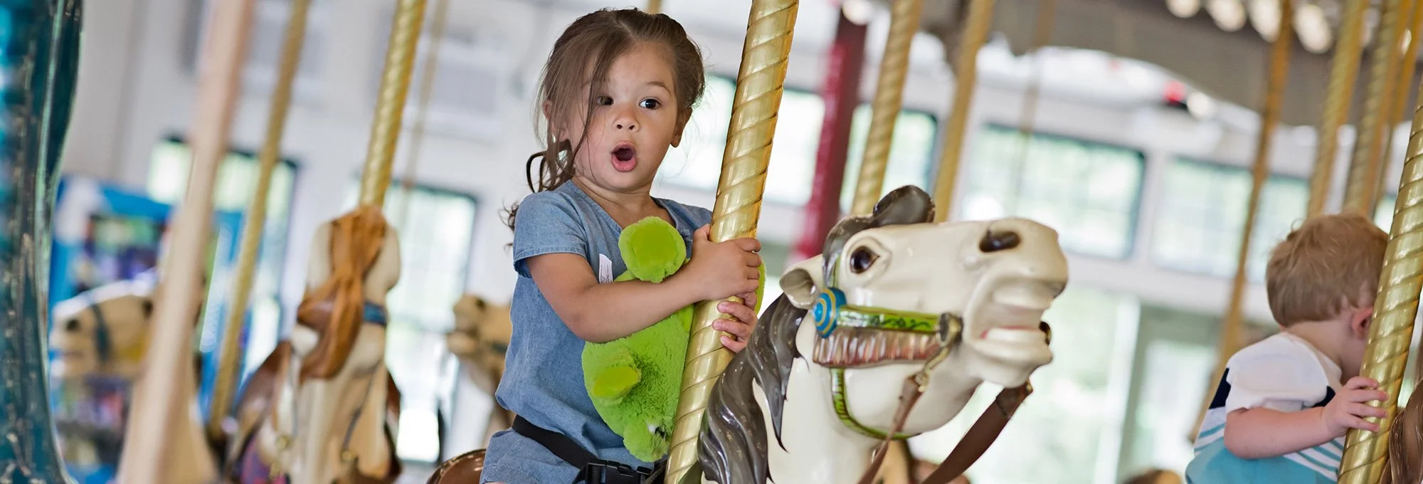 young girl looking surprised on carousel ride