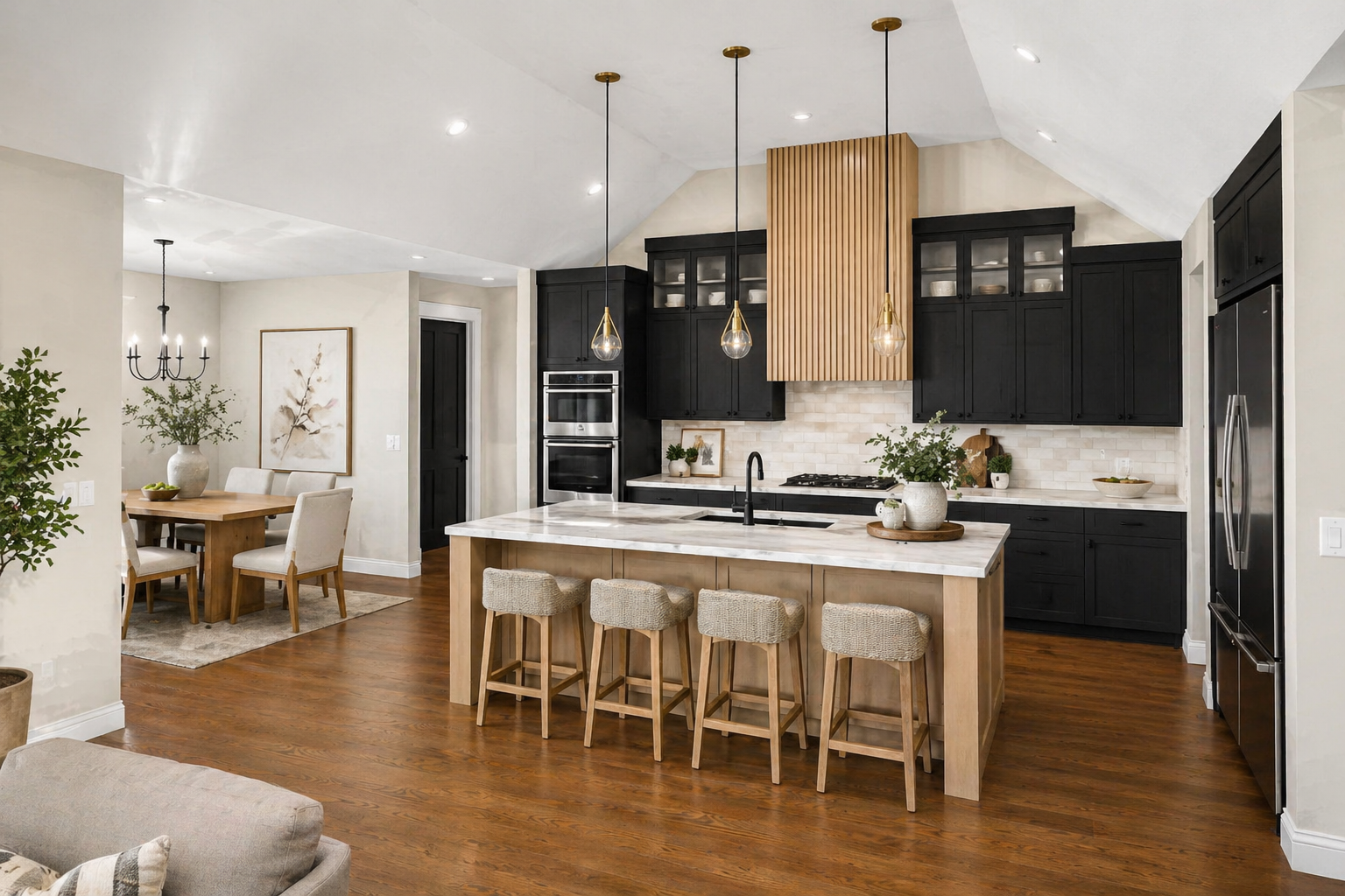 Modern kitchen with black cabinets, a white marble island with beige bar stools, and wooden accents. Adjacent dining area with a wooden table and beige chairs.