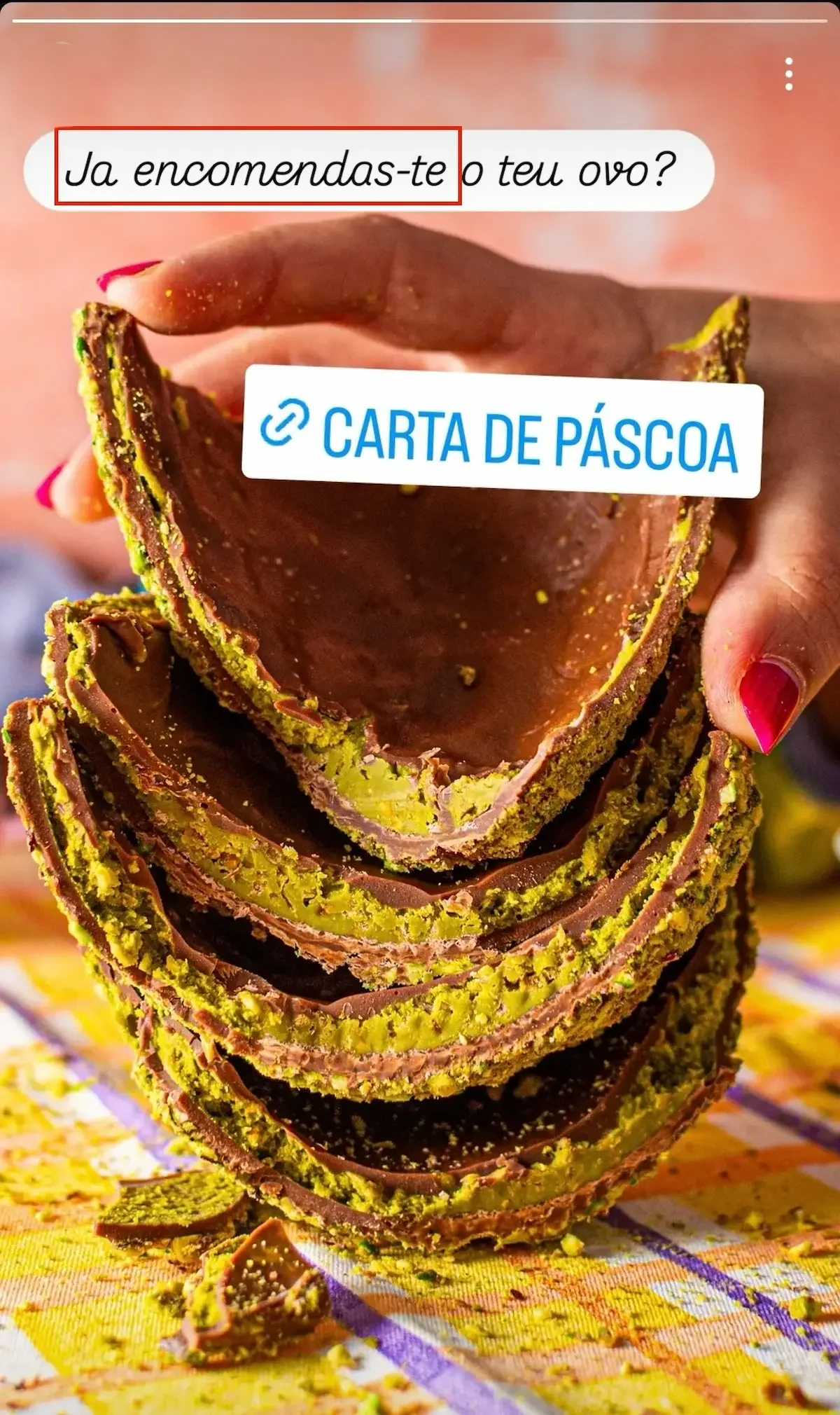 Hand holding a stack of chocolate and pistachio Easter egg halves