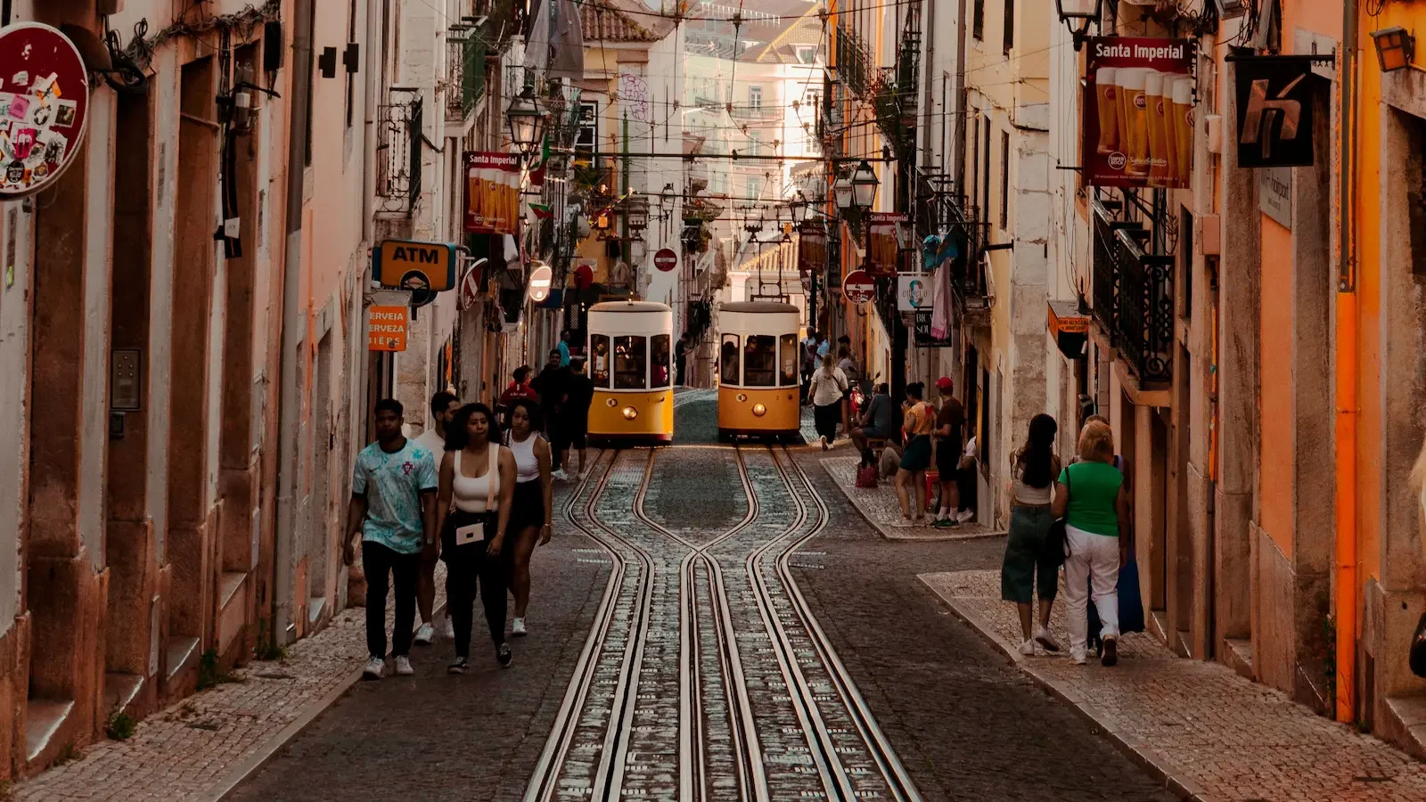 Two trams side by side up a typical Portuguese cobblestone street