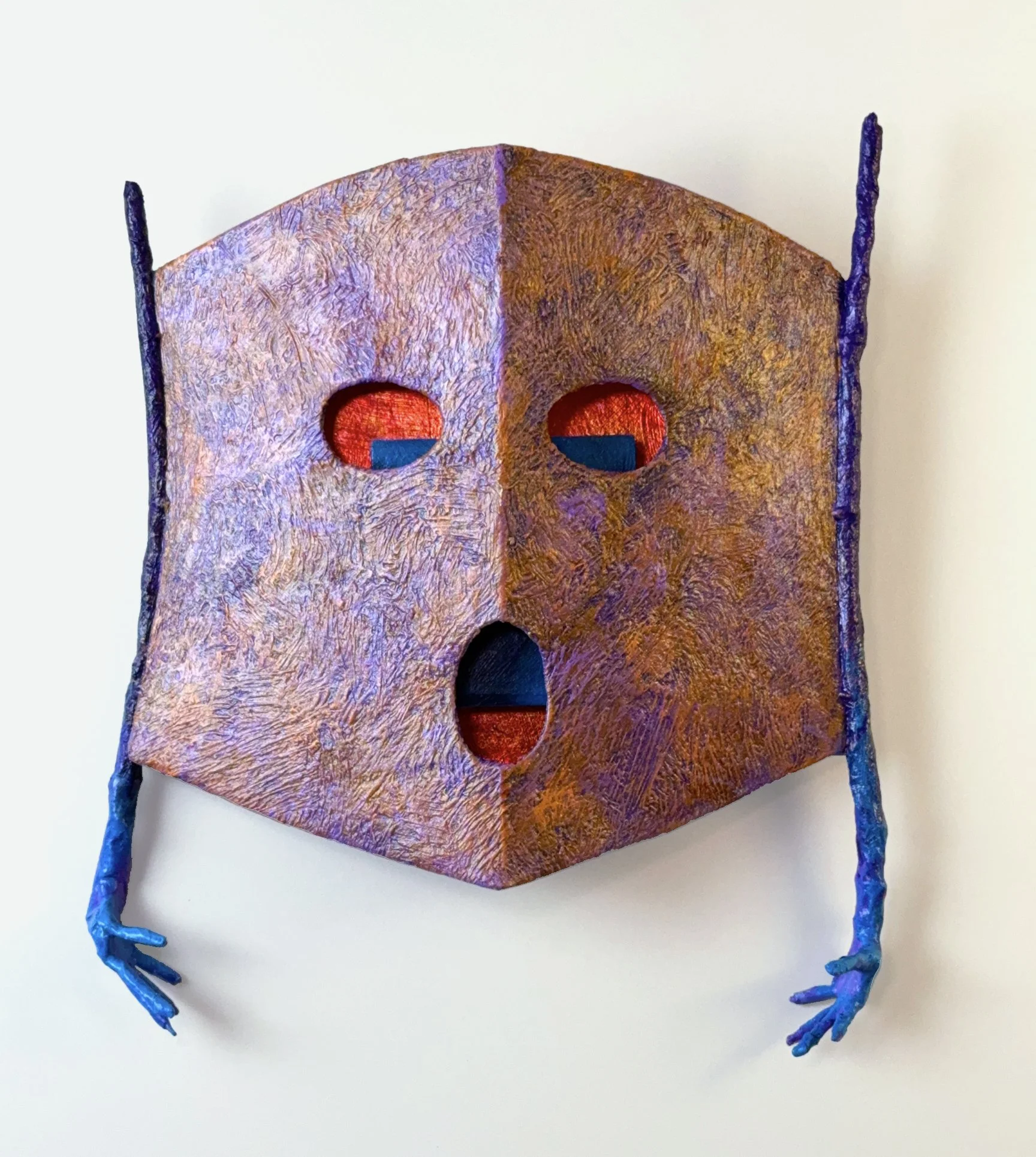 A multiple layered mask with glazes over gold leaf as the deepest layer.