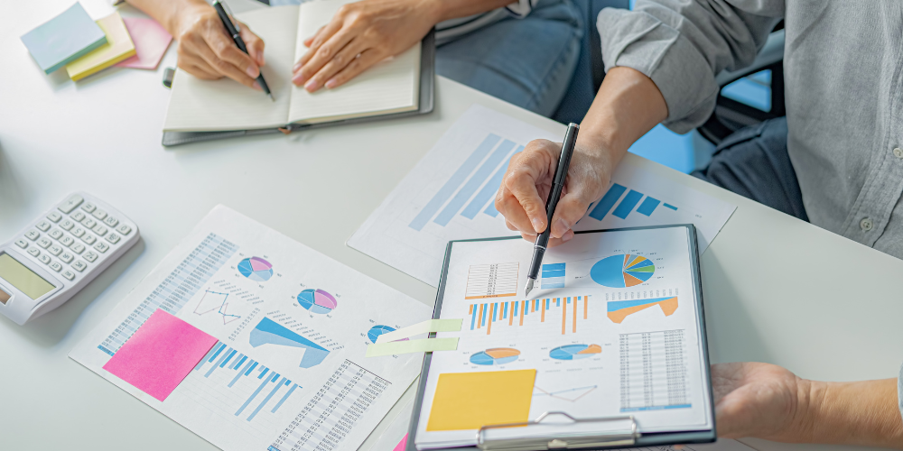 People reviewing financial charts and documents while managing their own finances.