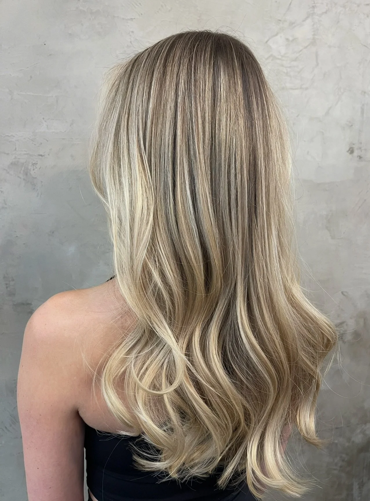 Long, rooted blonde hair, dimensional, cool/neutral blonde.