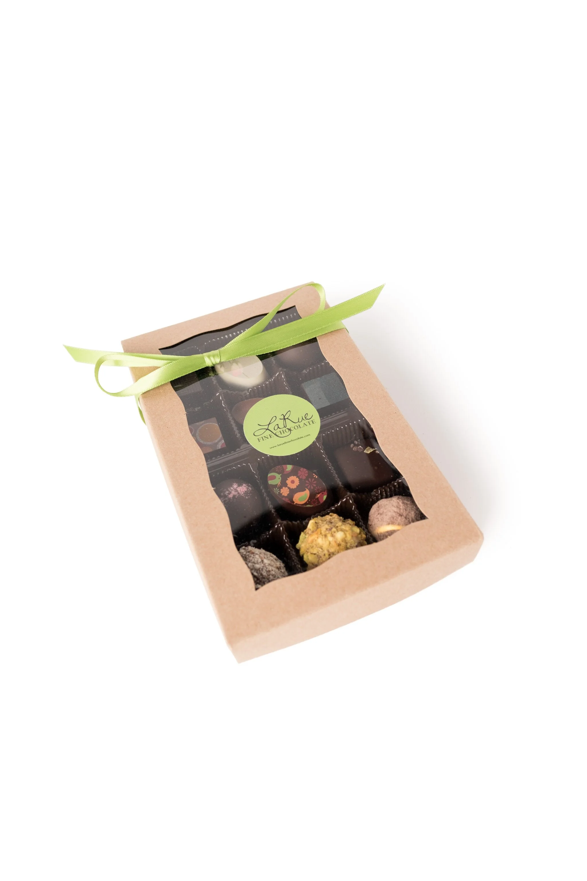 Box of assorted chocolates with a clear plastic window, tied with a green ribbon.