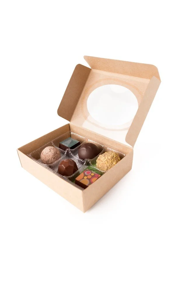 Open box of assorted chocolates with six different pieces inside.