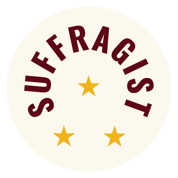 A logo for the Shall Men Vote? brand featuring a cream-colored circle with the word 'SUFFRAGIST' in maroon, arching across the top. Inside the circle are three gold stars arranged in a triangle.