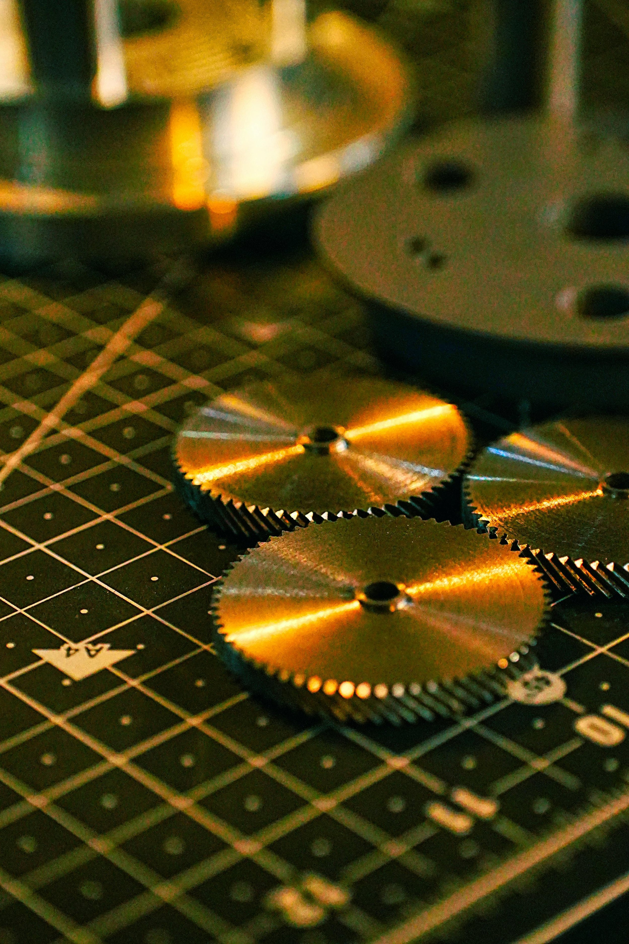 Close-up of metallic gears and mechanical parts on a black cutting mat.