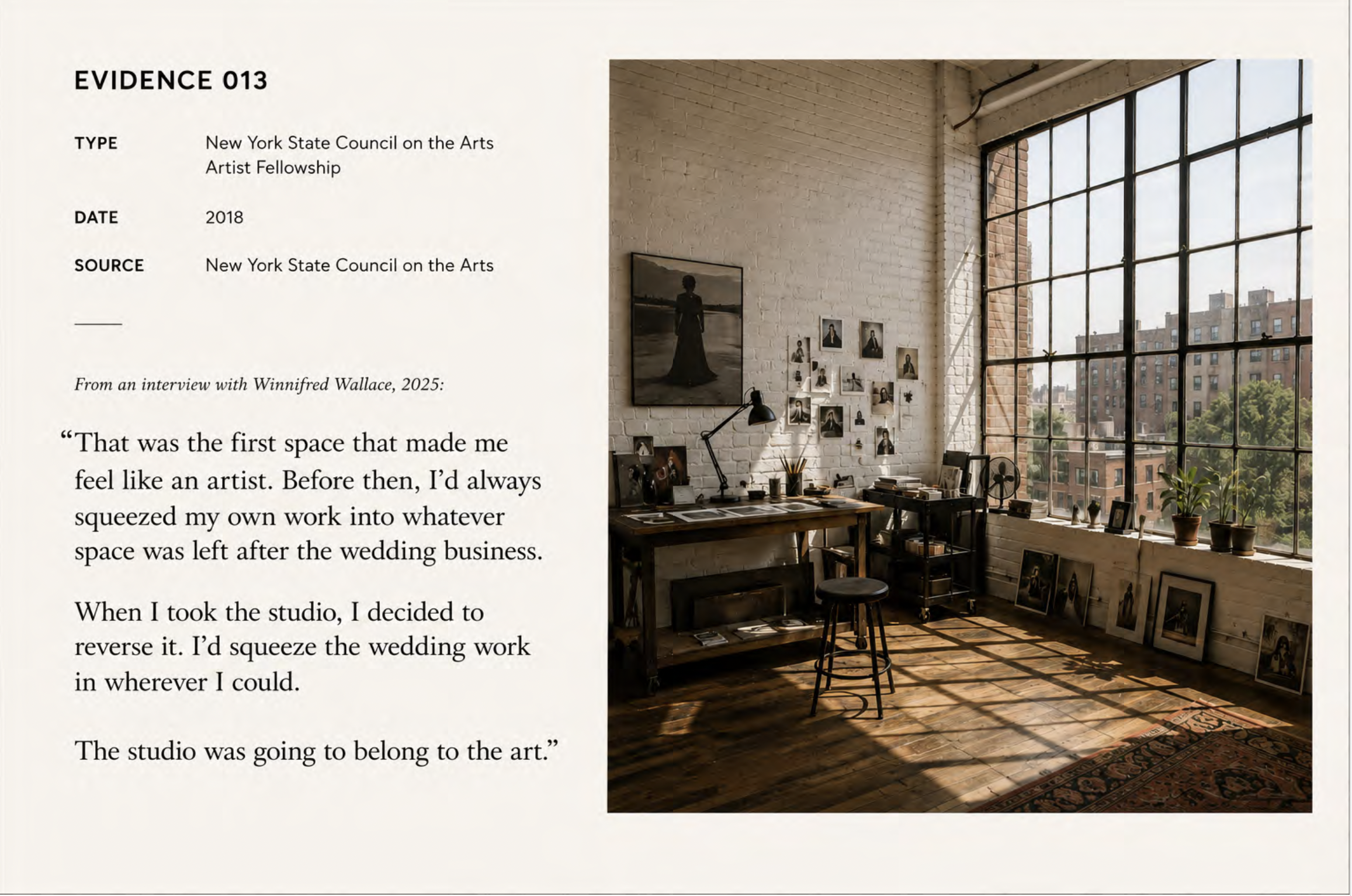 Bright art studio with a large window, white brick walls, art supplies, framed photographs, and artworks on display, with sunlight casting shadows on a wooden floor.