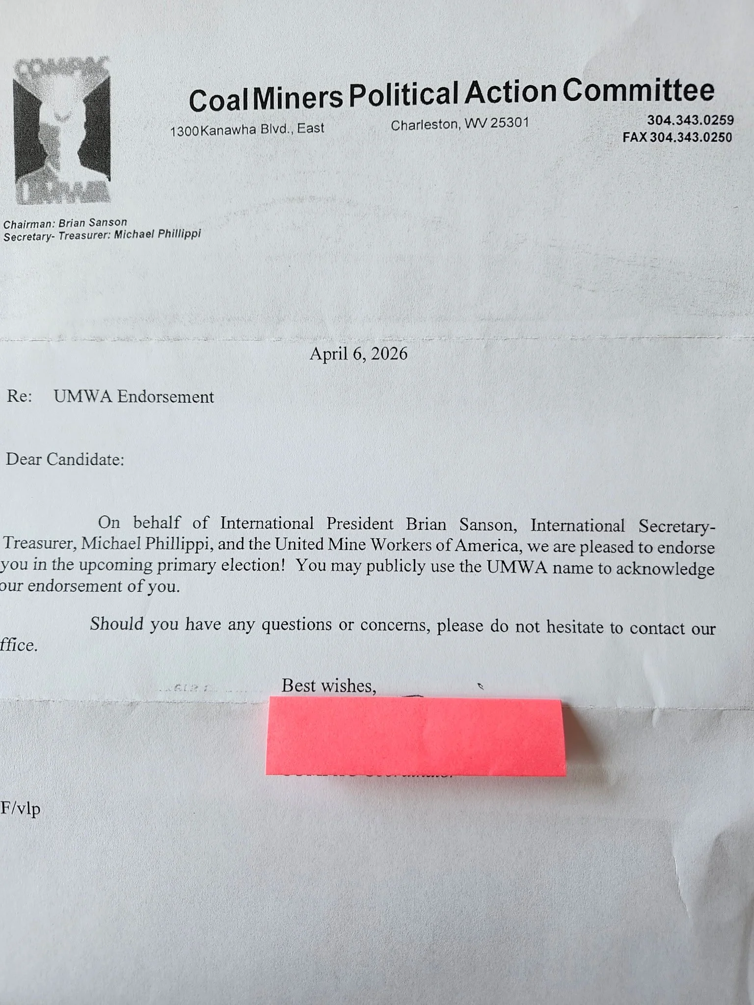 A letter on white paper with a black and white logo of a rising bull and a mountain peak, addressed to a candidate, endorsing them for an election, signed by international officials, with a pink sticky note attached at the bottom.