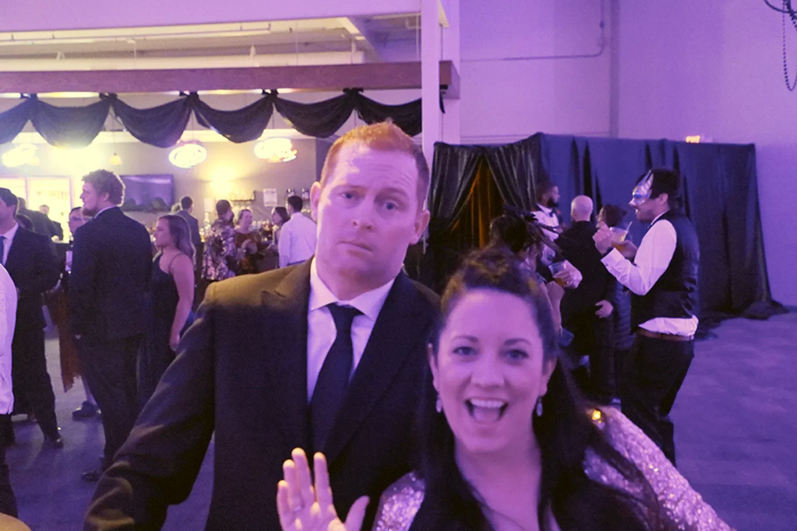 aqua-christmas-masquerade-2022-candid-late-night-mingling-pink-light.webp
