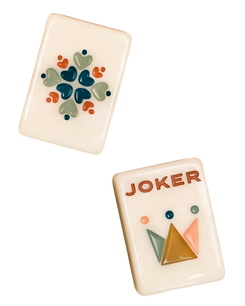 Two mahjong tiles with colorful, abstract designs on their faces, one featuring heart shapes and the other with the word 'JOKER' and geometric patterns.
