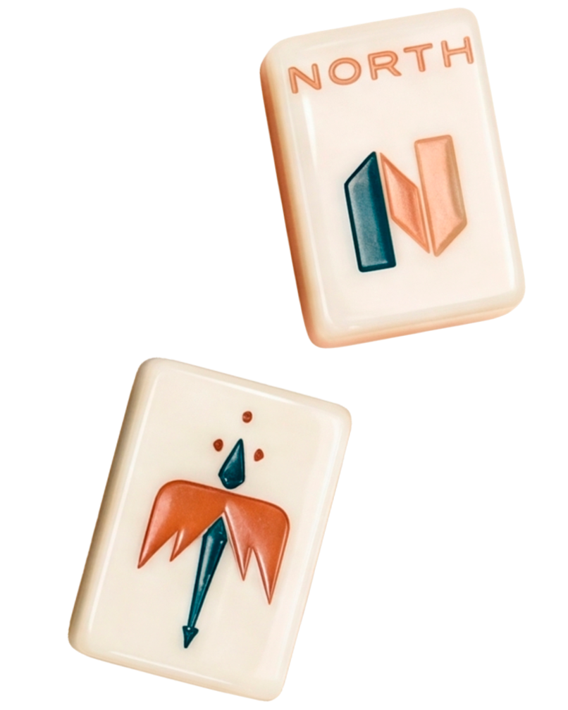 Two mahjong tiles, one showing the word 'NORTH' and a stylized north wind symbol, the other depicting a simplified face of a person with orange hair and a blue nose.