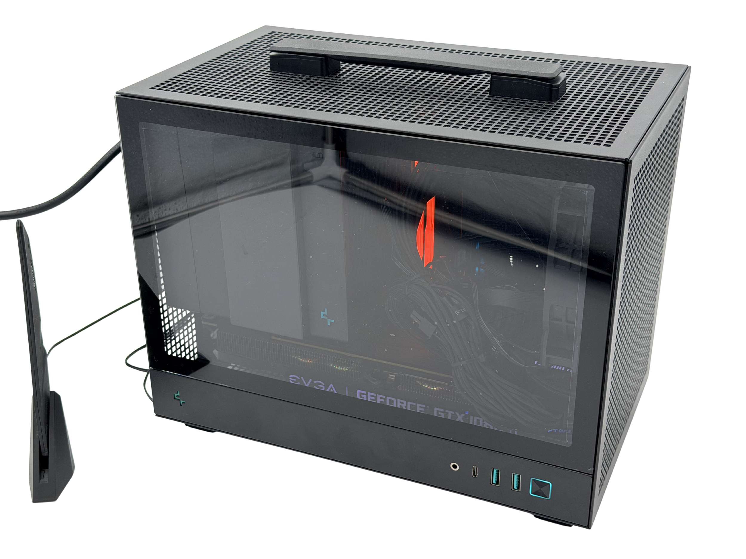 A black and gray computer case with a glass side panel, showcasing internal components including a graphics card. The case has a top ventilation grid and various USB ports on the front.
