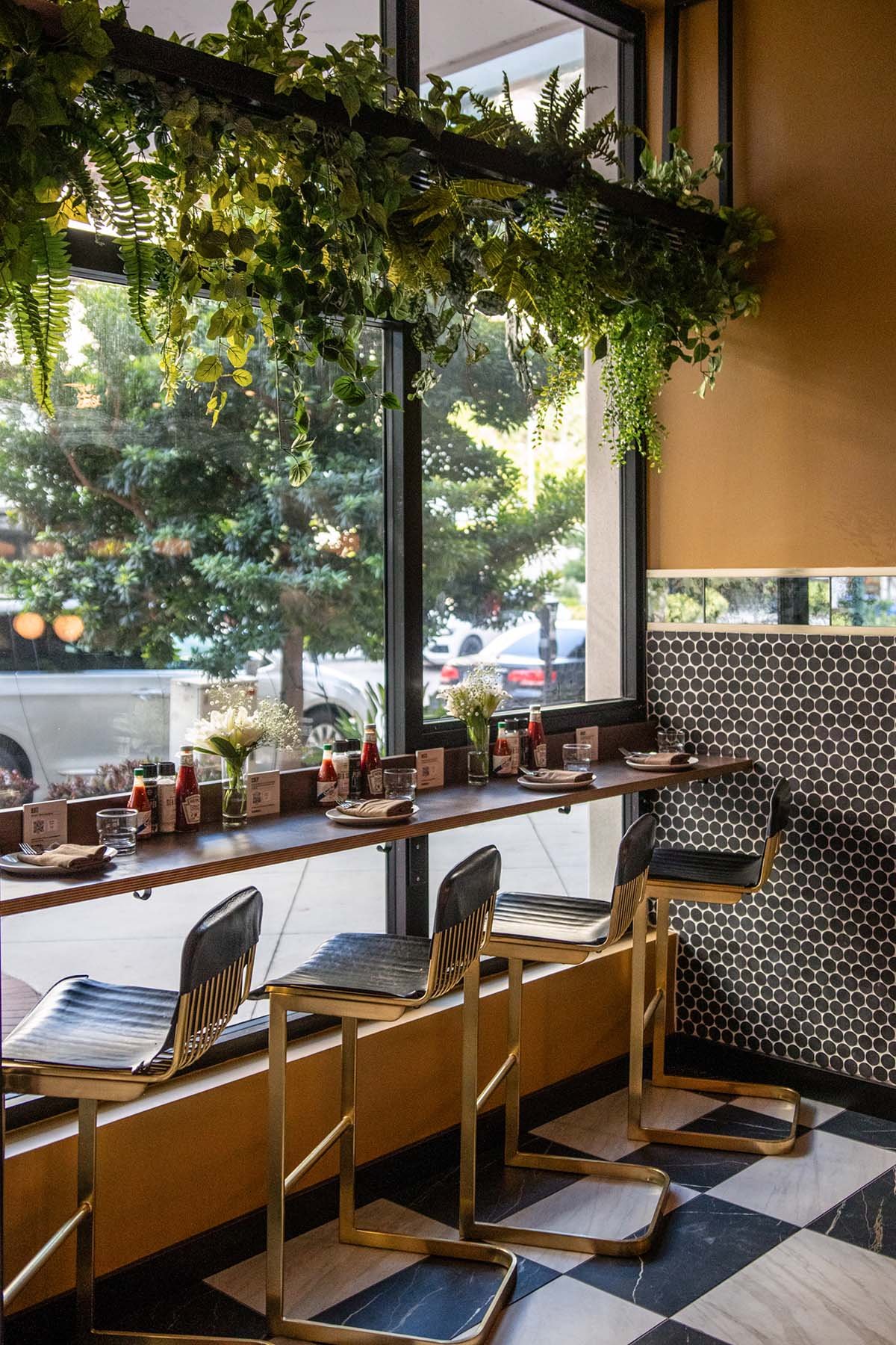 bar stools+plants+black penny tile+yellow walls.jpg