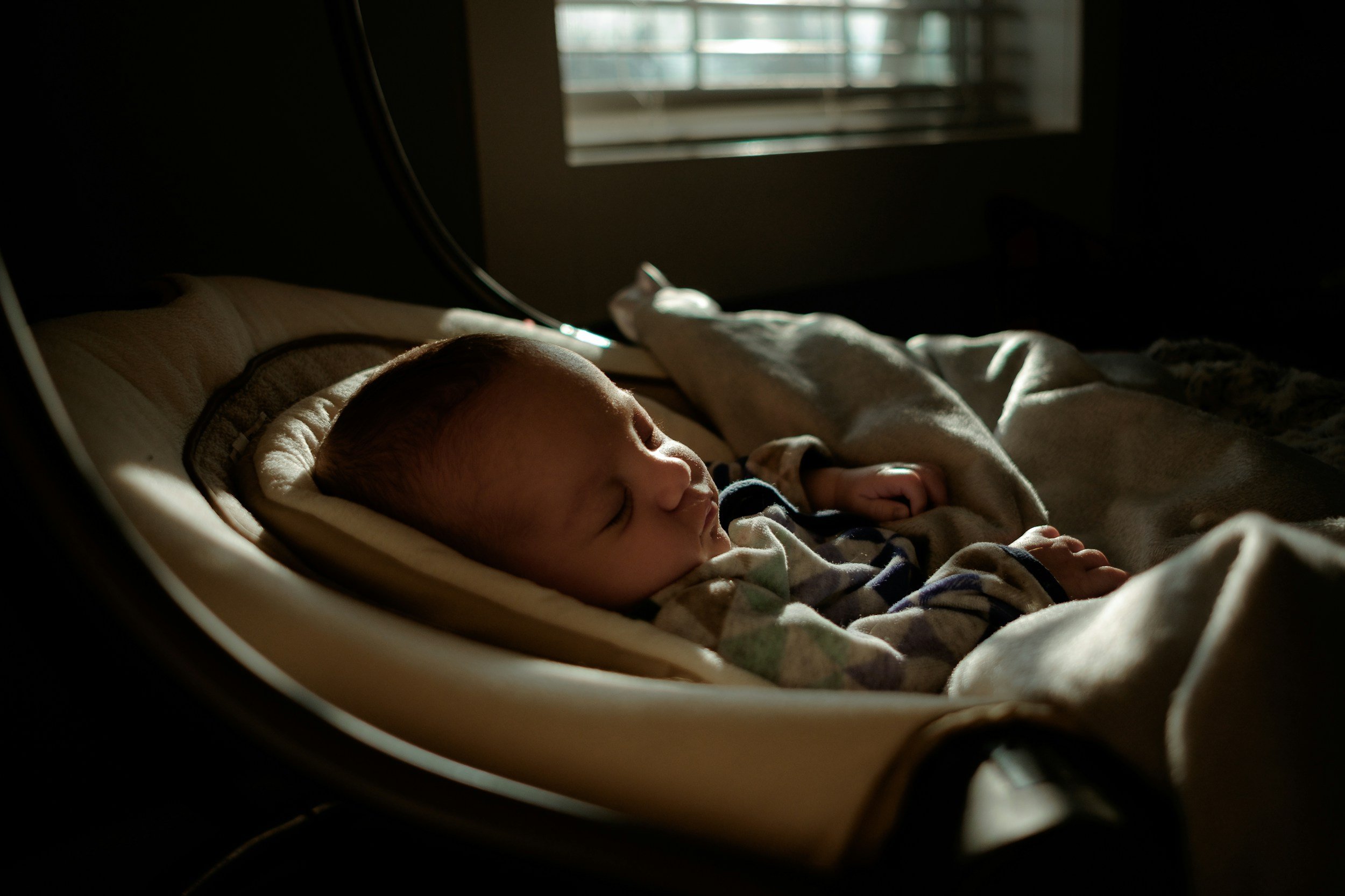 Un bebé dormido en una cuna en una habitación con luz natural