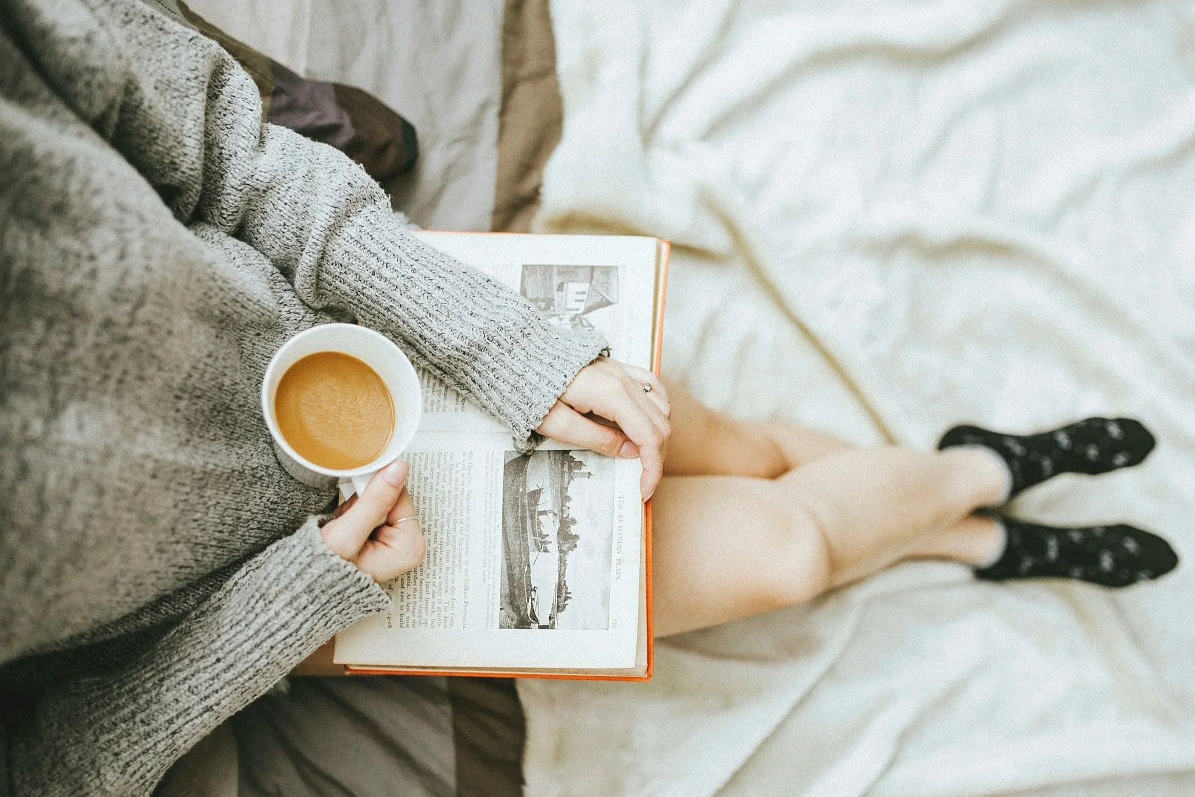 Parent relaxing with a cup of tea and reading a book during a peaceful evening routine