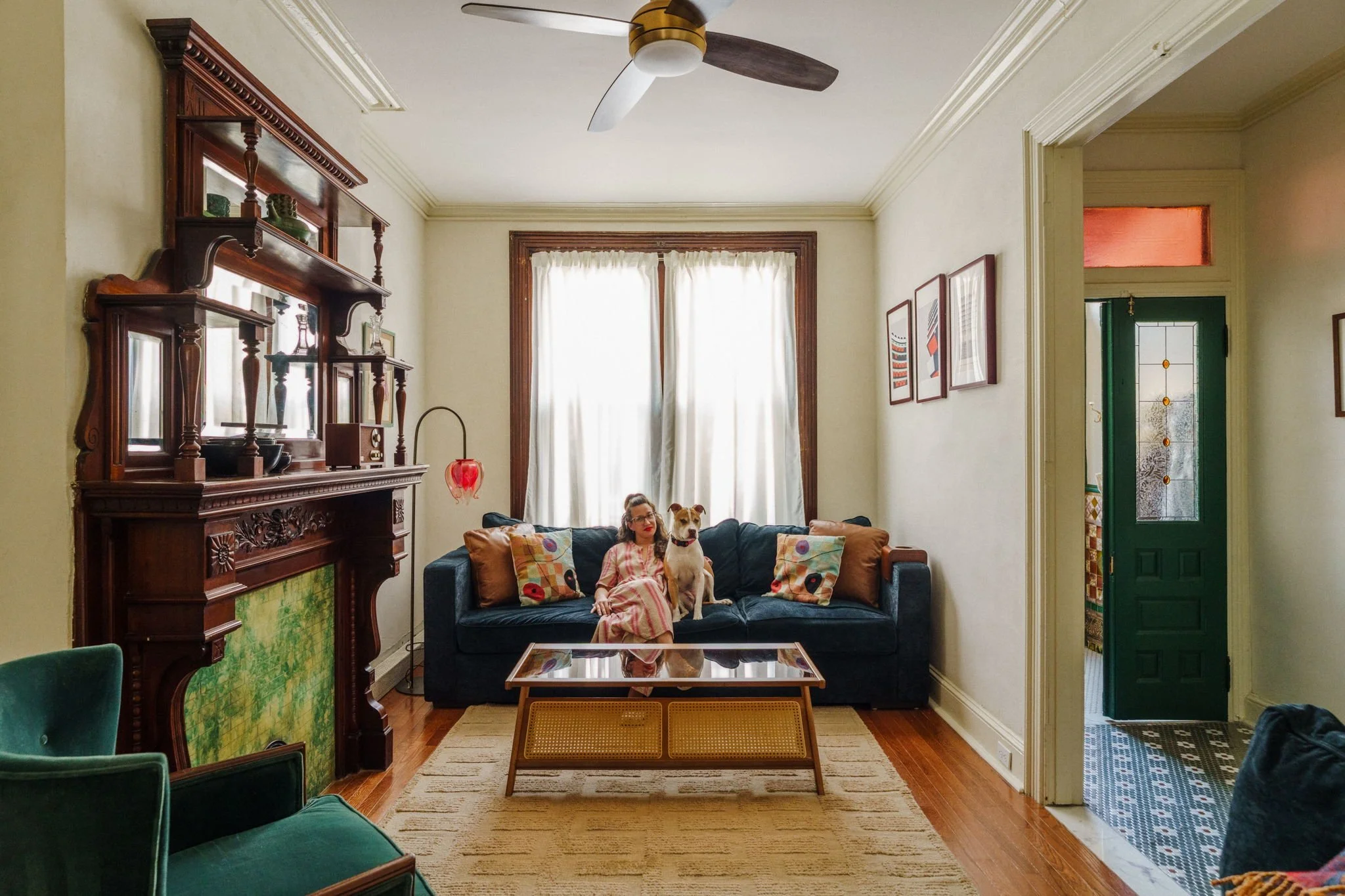 Jessica Hahn sits with her dog in a beautifully designed living room featuring timeless furnishings, curated artwork, and warm, inviting details that reflect her interior design style.