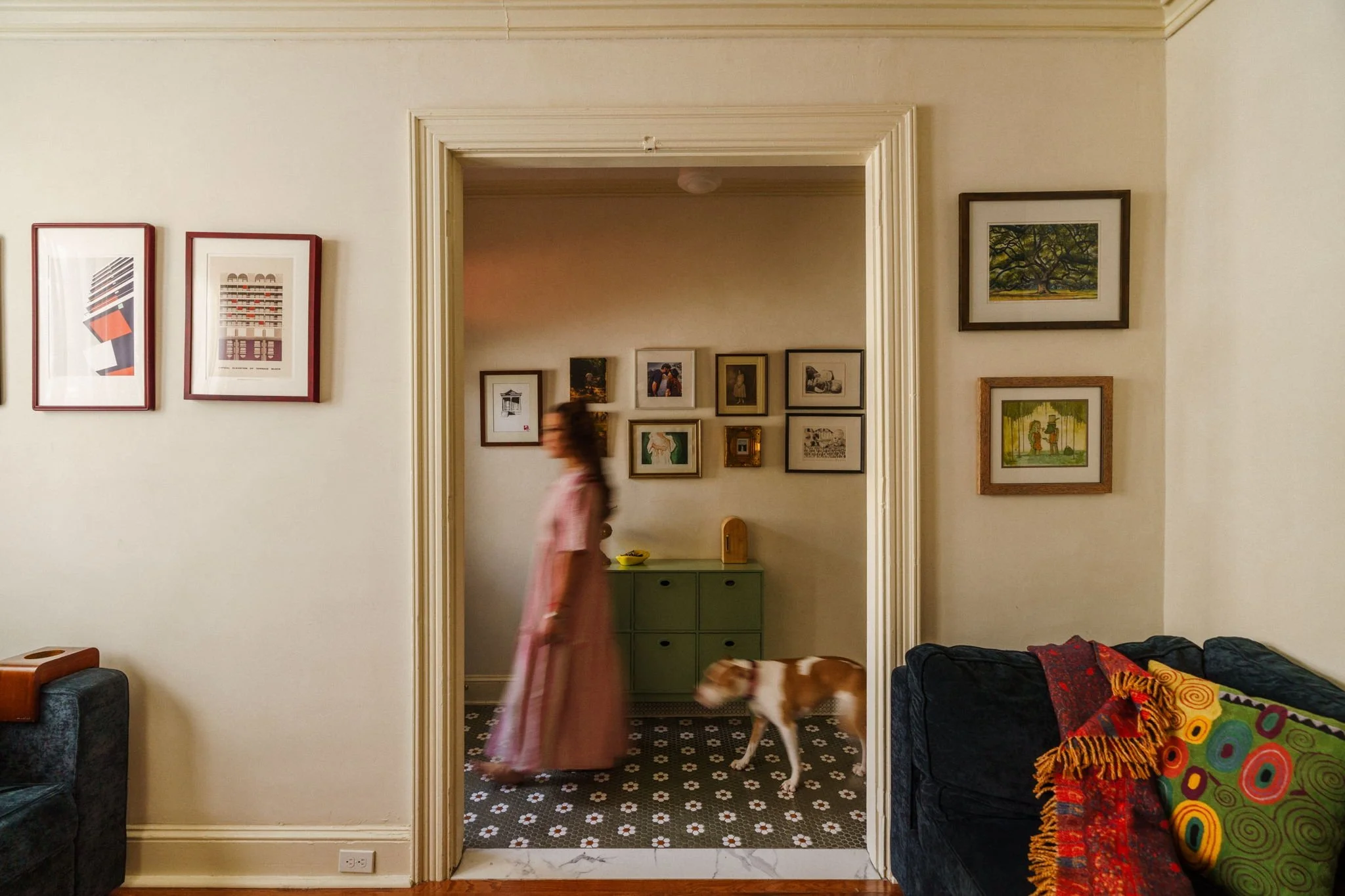 Woman walking down a hall with her dog behind her.