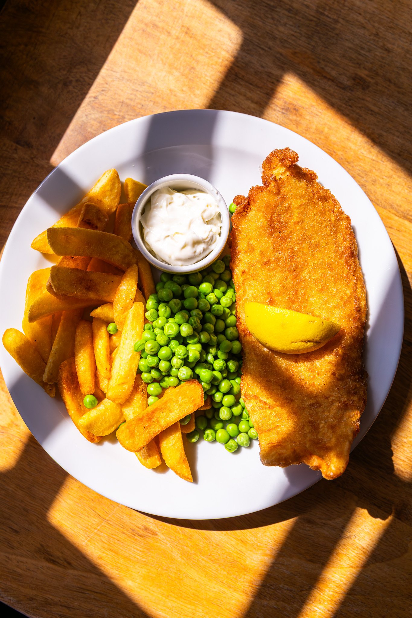 Plate of fish and chips with peas and tartar sauce