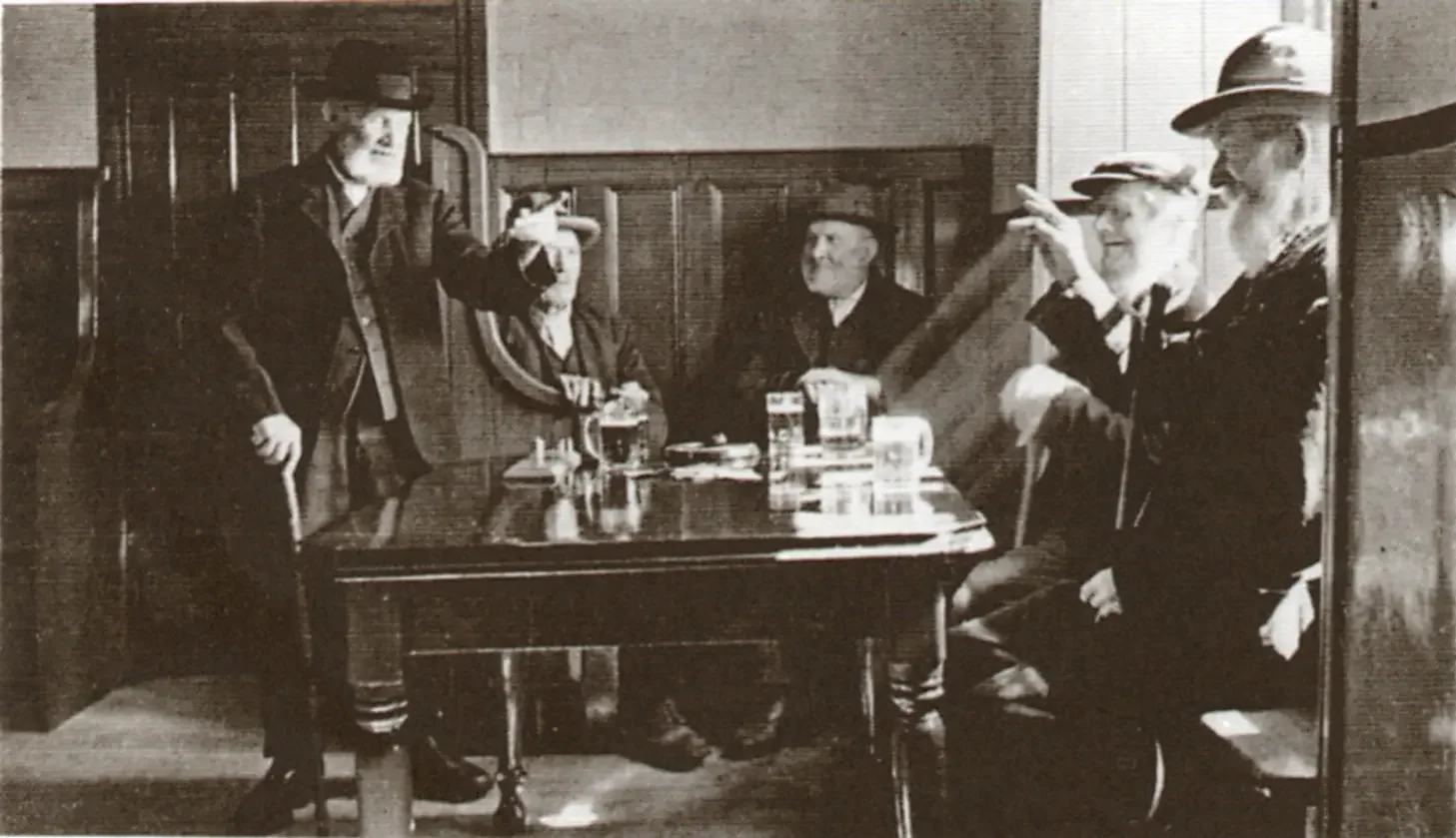 Men in vintage suits and hats playing cards at a wooden table in a cozy room, with drinks and cigarettes on the table.