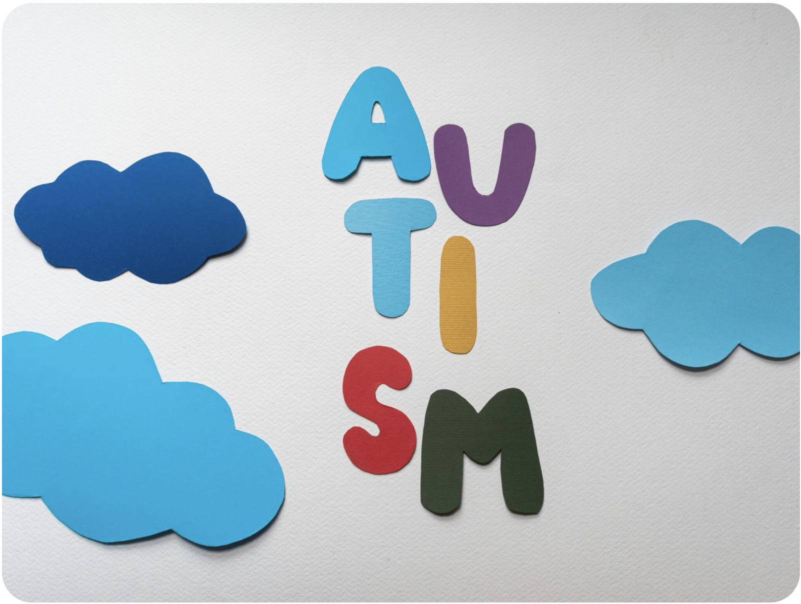 Colorful foam letters spelling 'AUTISM' surrounded by blue foam clouds on white background.