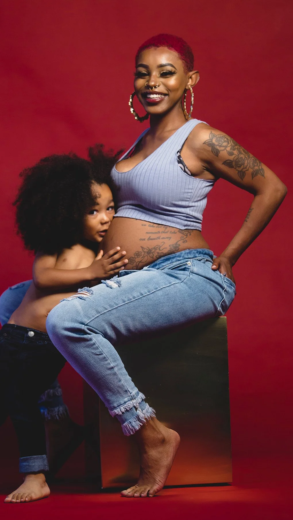 Photo of smiling Black pregnant woman with child