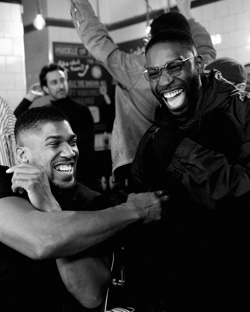 Anthony Joshua and Tinie Tempah laughing together, behind the scenes of a LYNX campaign shoot in London.