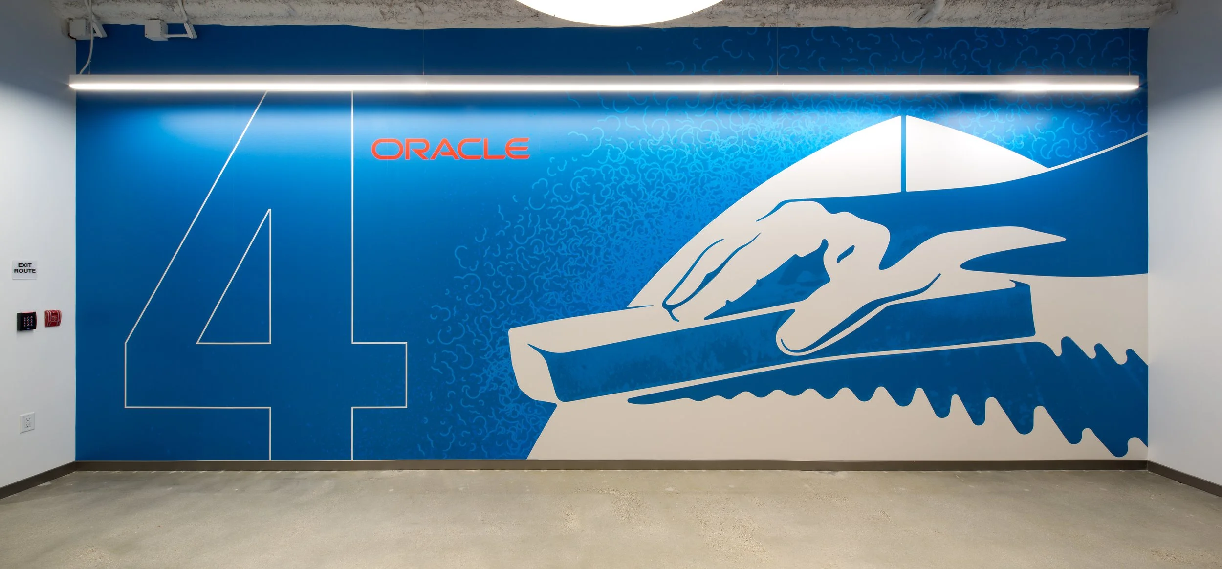 Blue wall mural featuring a large white number 4, a stylized hand holding a saw, and the word 'Oracle' in red letters.