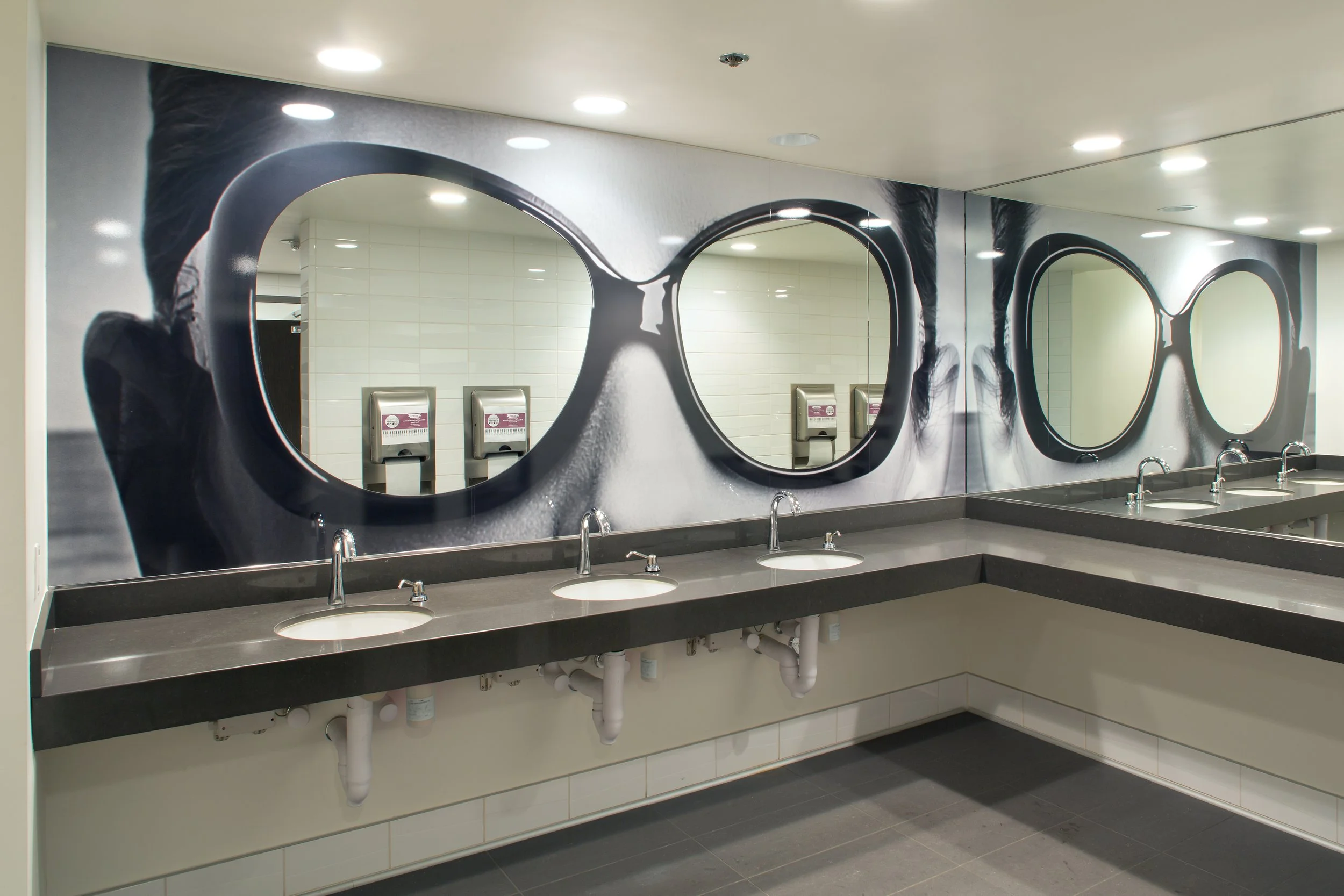 Restroom sinks with large mirrors and faucet fixtures in a public bathroom.
