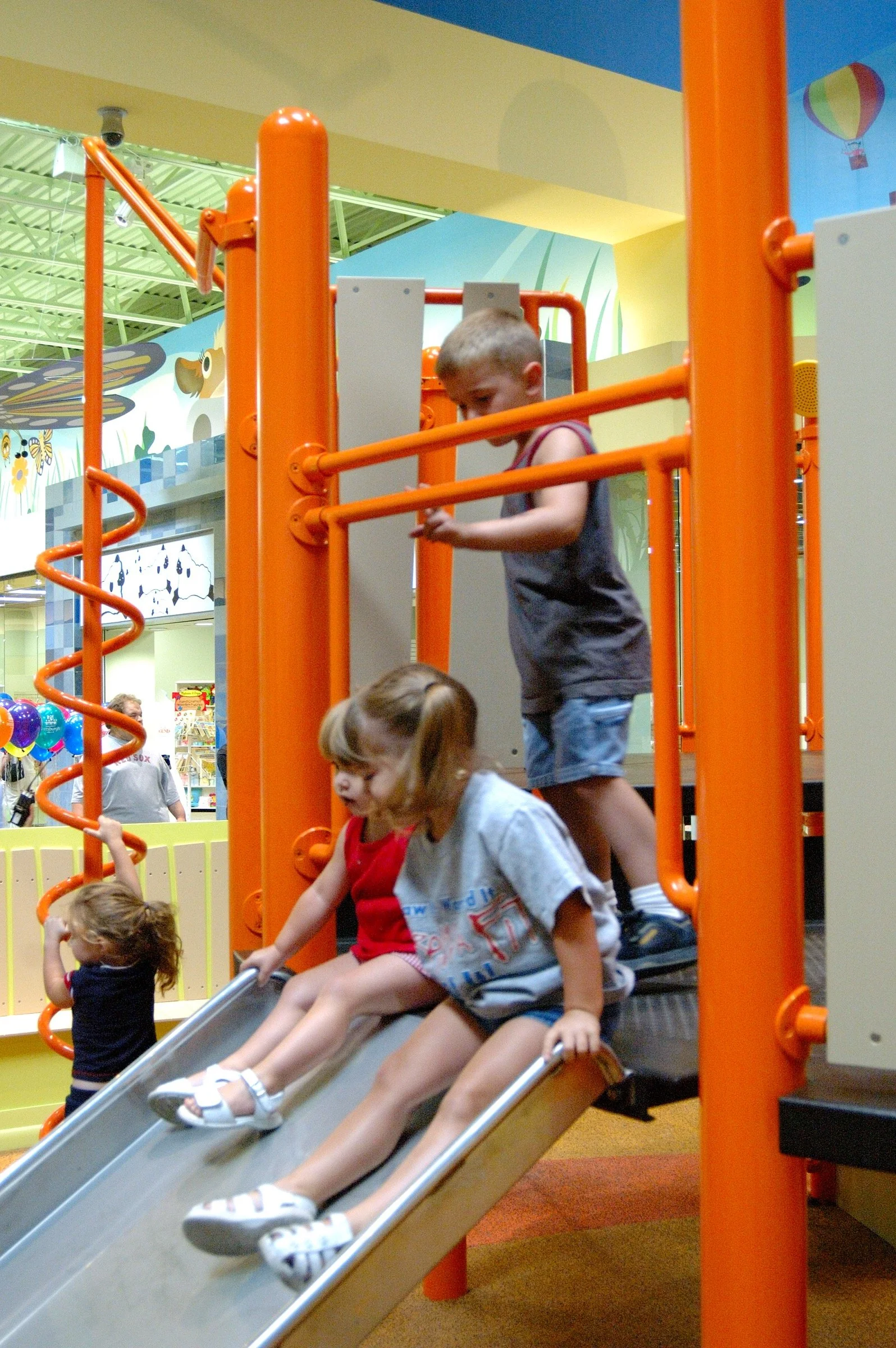 Children playing in the PBS Kids Backyard play zone.