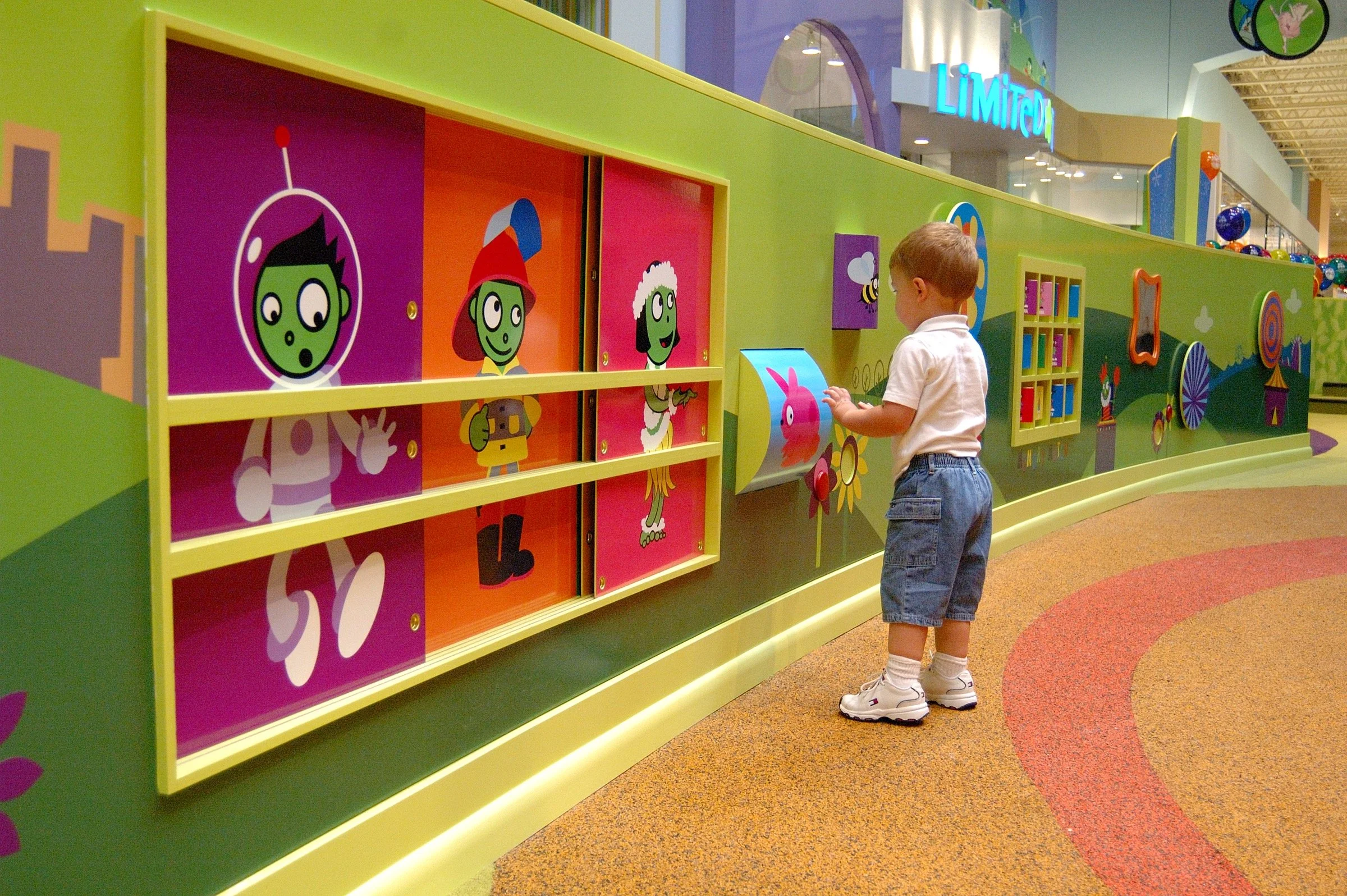 Children playing in the PBS Kids Backyard play zone.