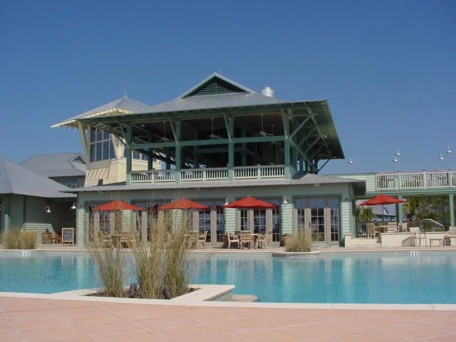 Luxury outdoor pool area with a two-story building and a clear blue sky