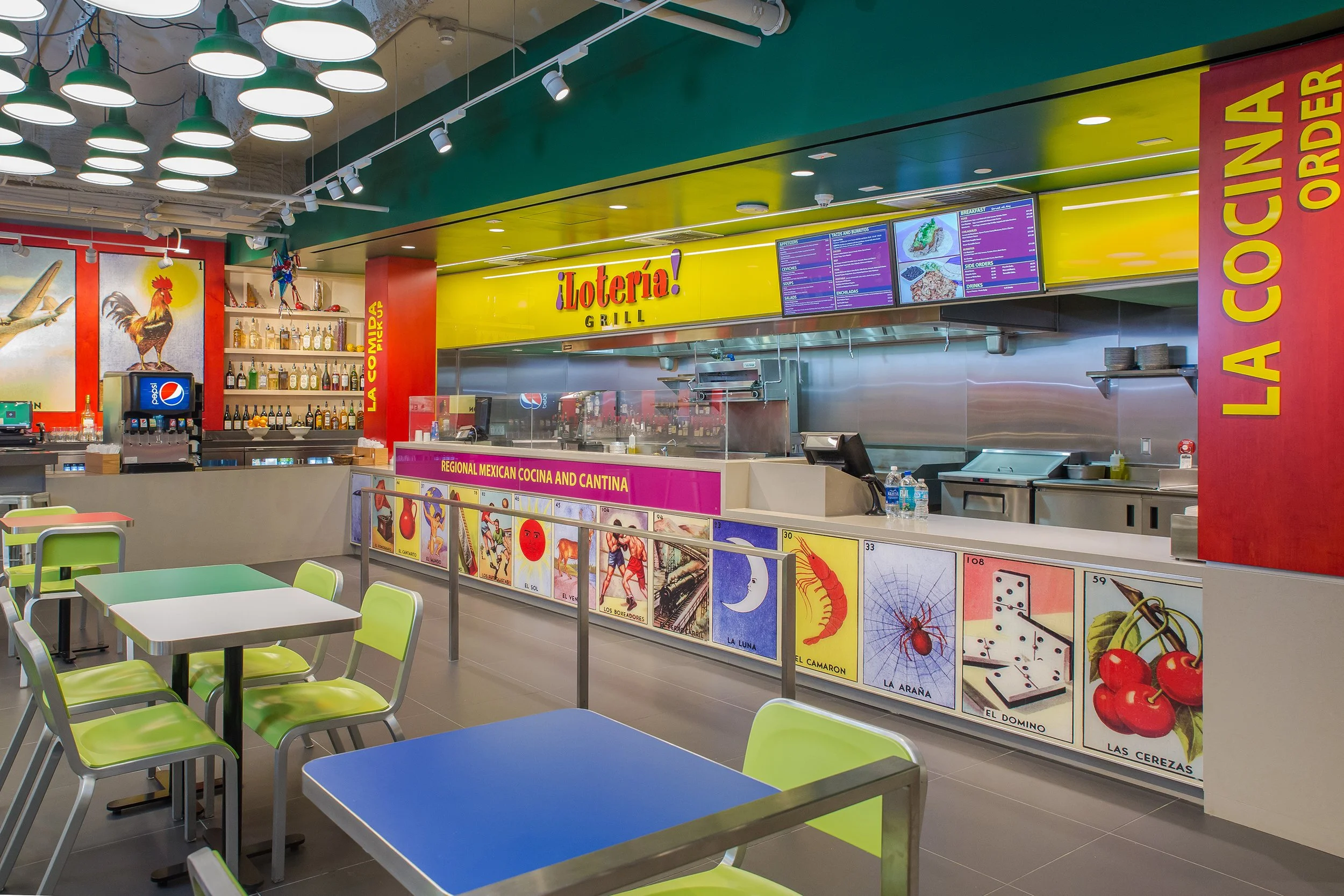 Interior of a colorful restaurant called La Loteria Grill with digital menu boards, seating tables with lime green chairs, and vibrant wall art and posters.