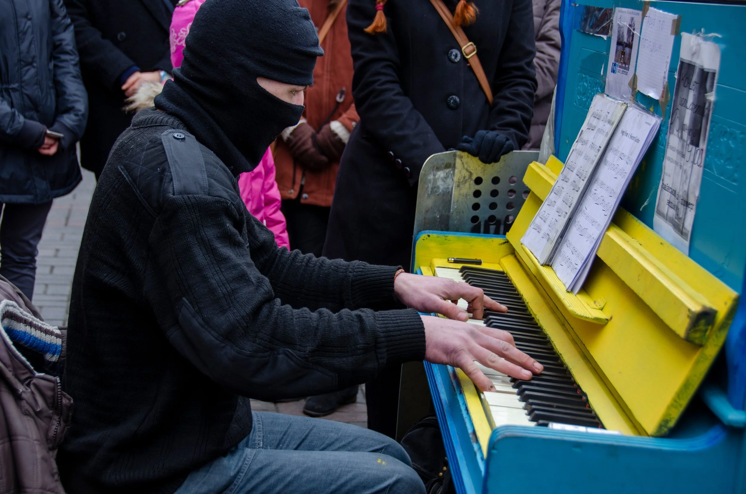 man with face covered playing piano