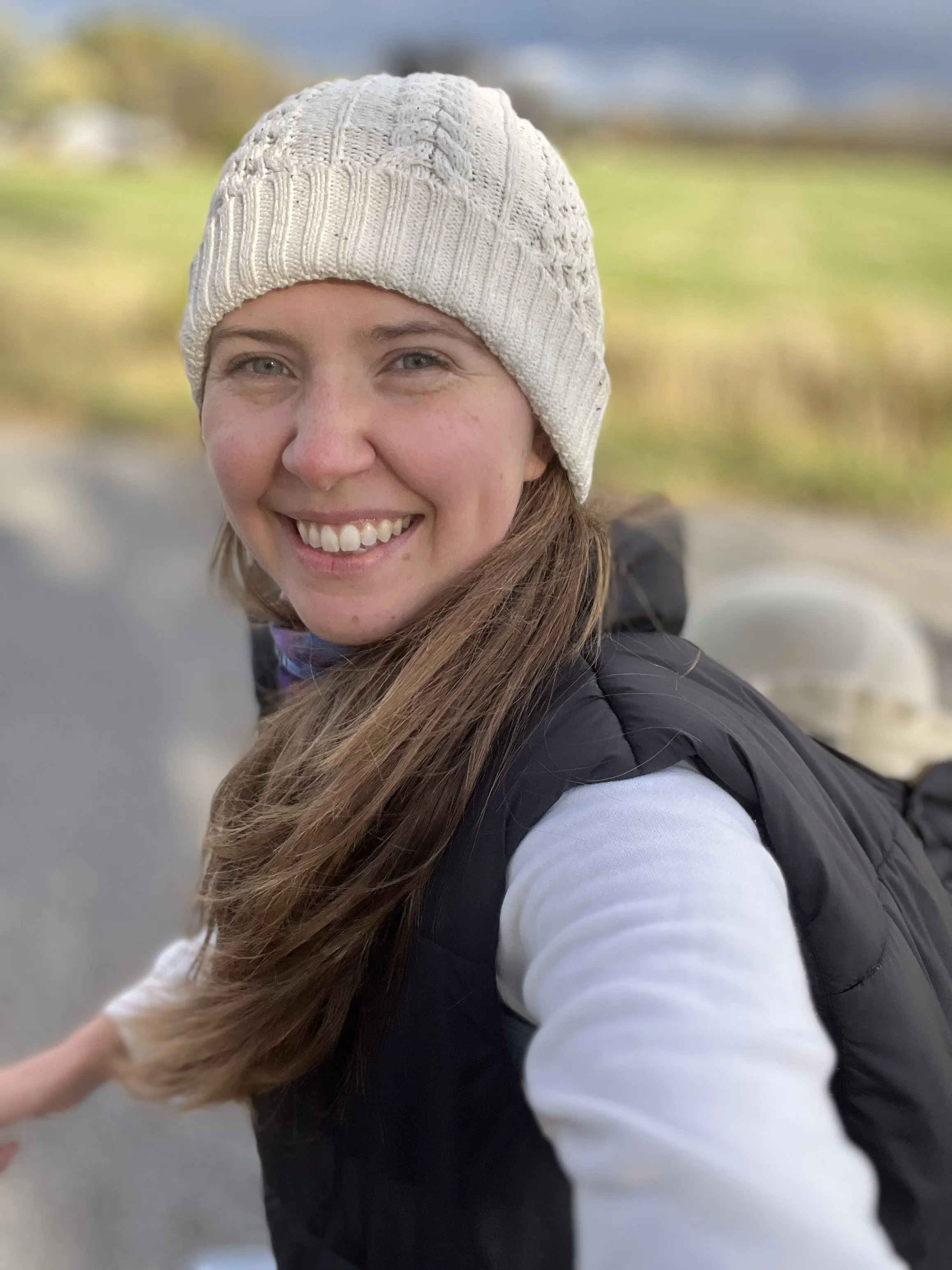 Kelsey Hughes certified babywearing educator on a fall walk in Metro Detroit with baby in a back carry under a babywearing coat