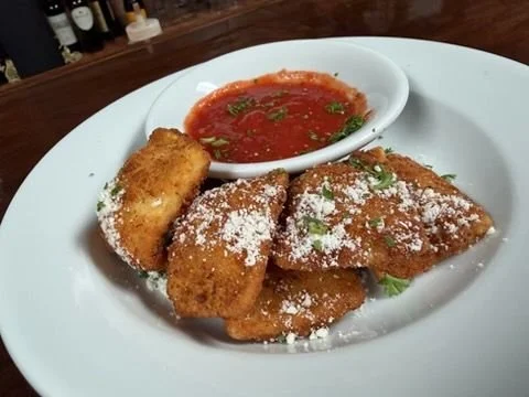 Fried fish fillets topped with powdered cheese, served with a side of red dipping sauce
