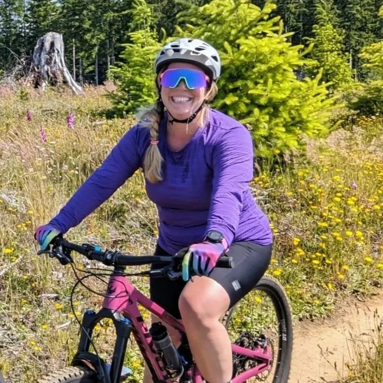 Woman riding a mountain bike on a trail.