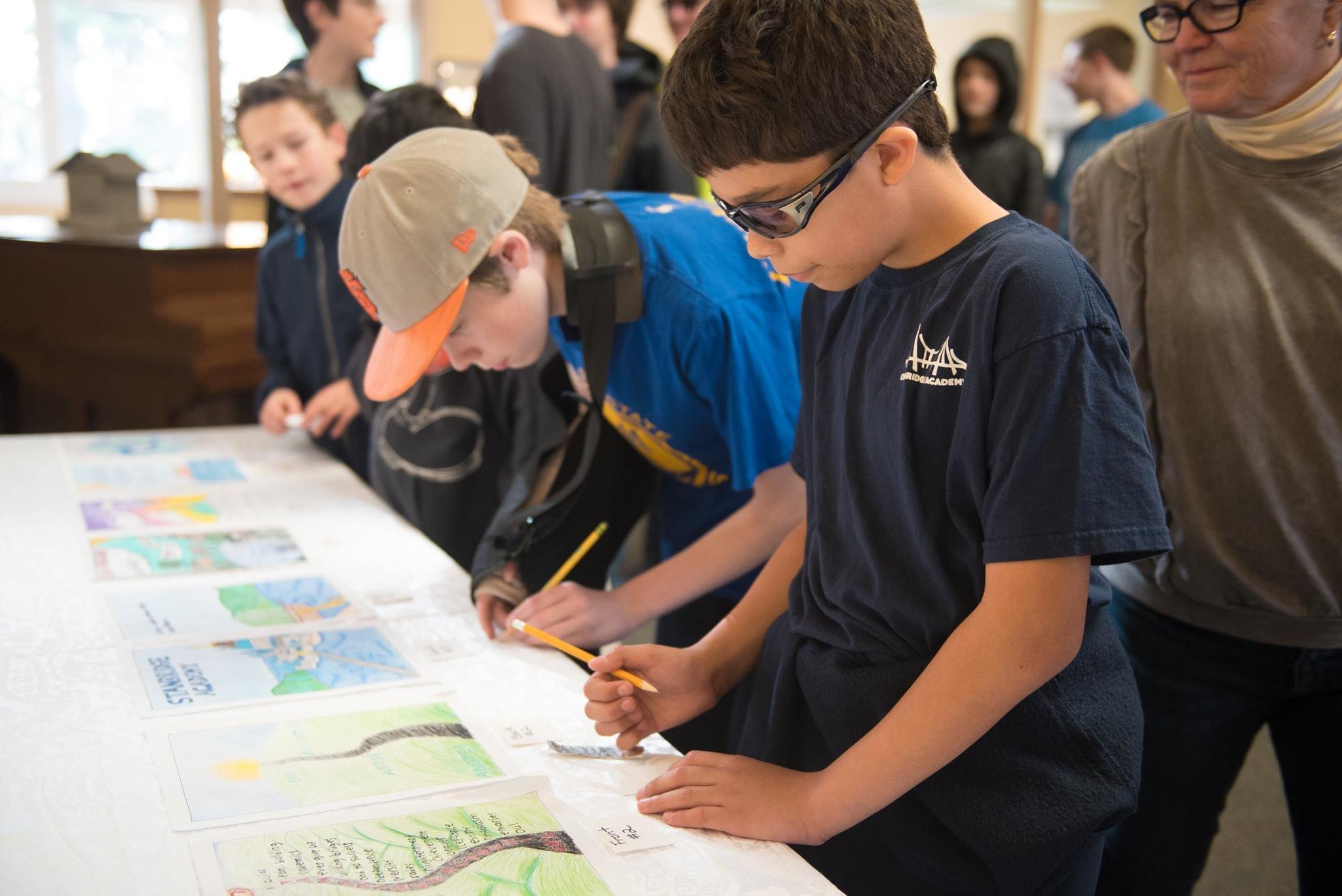 students writing notes on hand-drawn cover designs