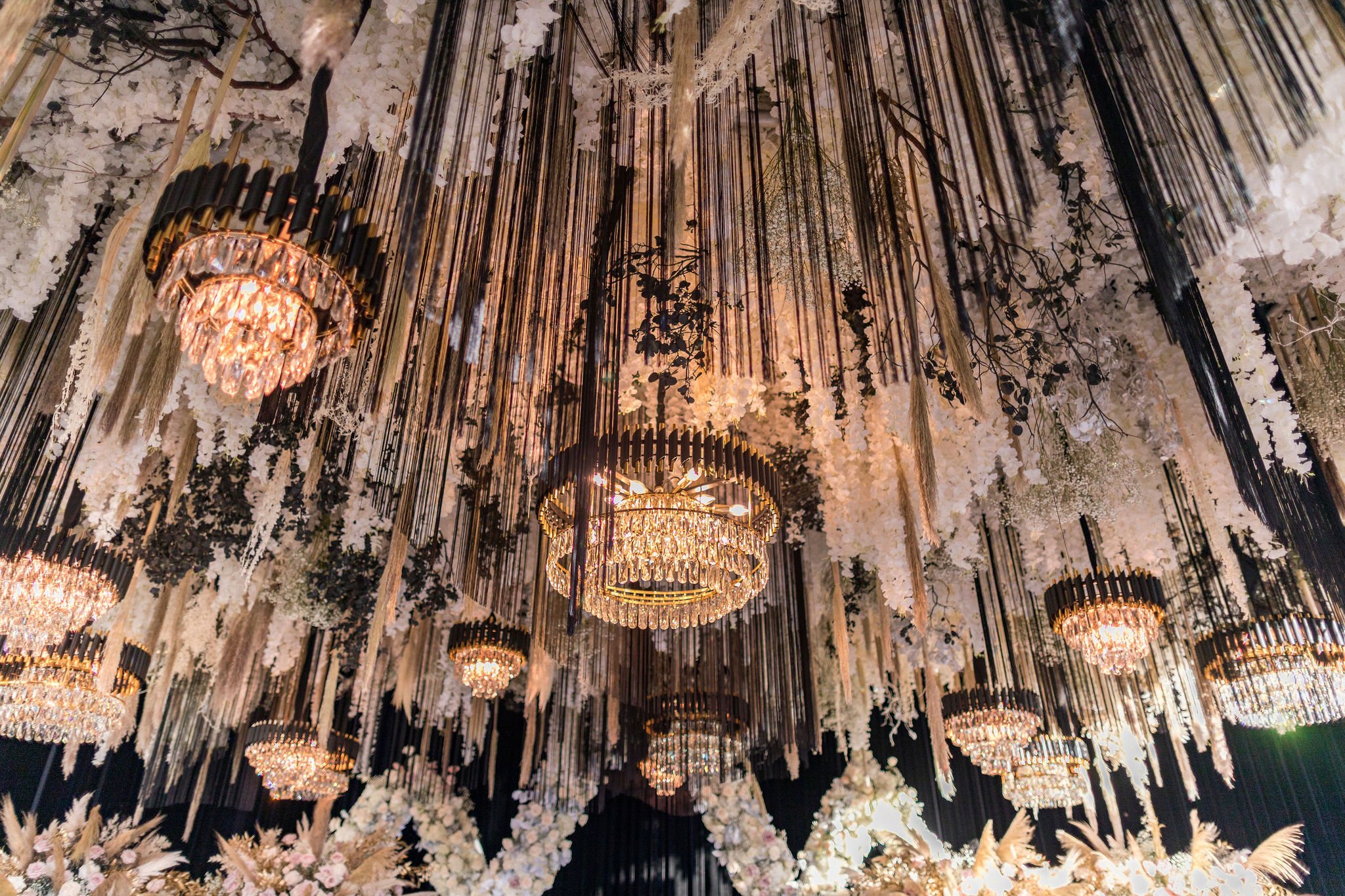 Ornate ceiling decorated with hanging flowers, black ribbons, crystal chandeliers, and gold accents.