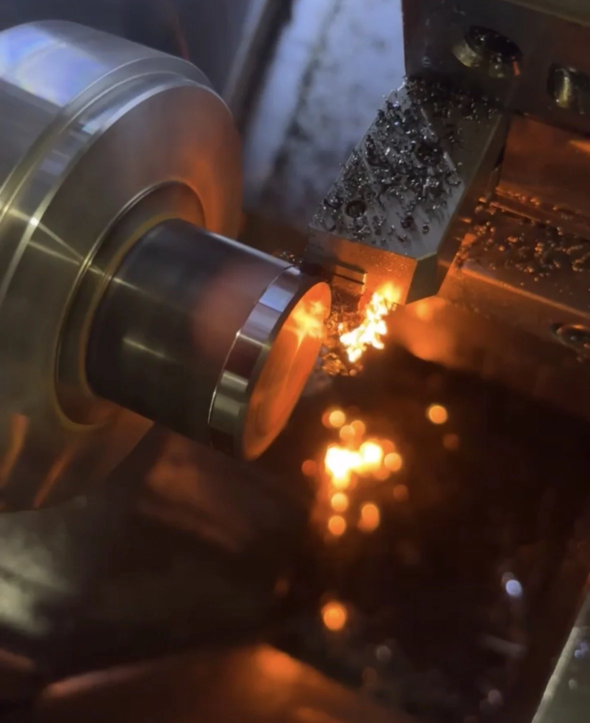 A metal piece being welded or cut with a welding torch, producing sparks and bright orange flames.