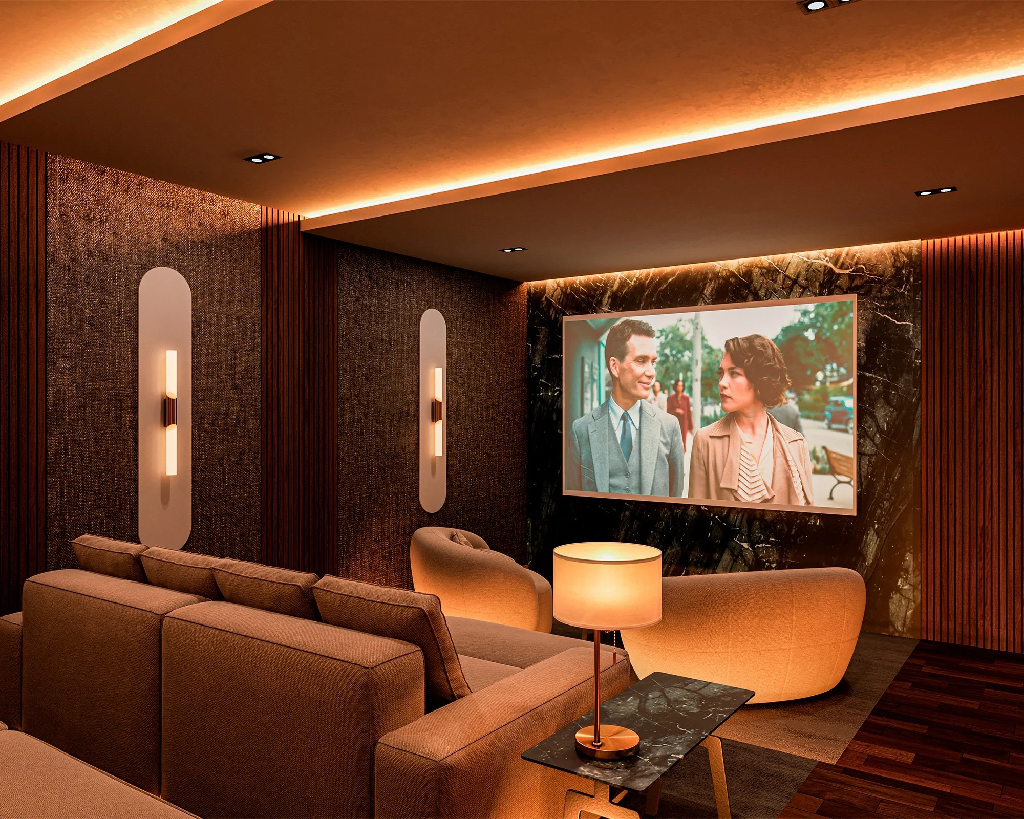 Interior de una sala con sillones beige, lámpara de mesa y paredes decoradas en tonos oscuros con iluminación cálida, pantalla de televisión mostrando dos personas hablando en la calle.