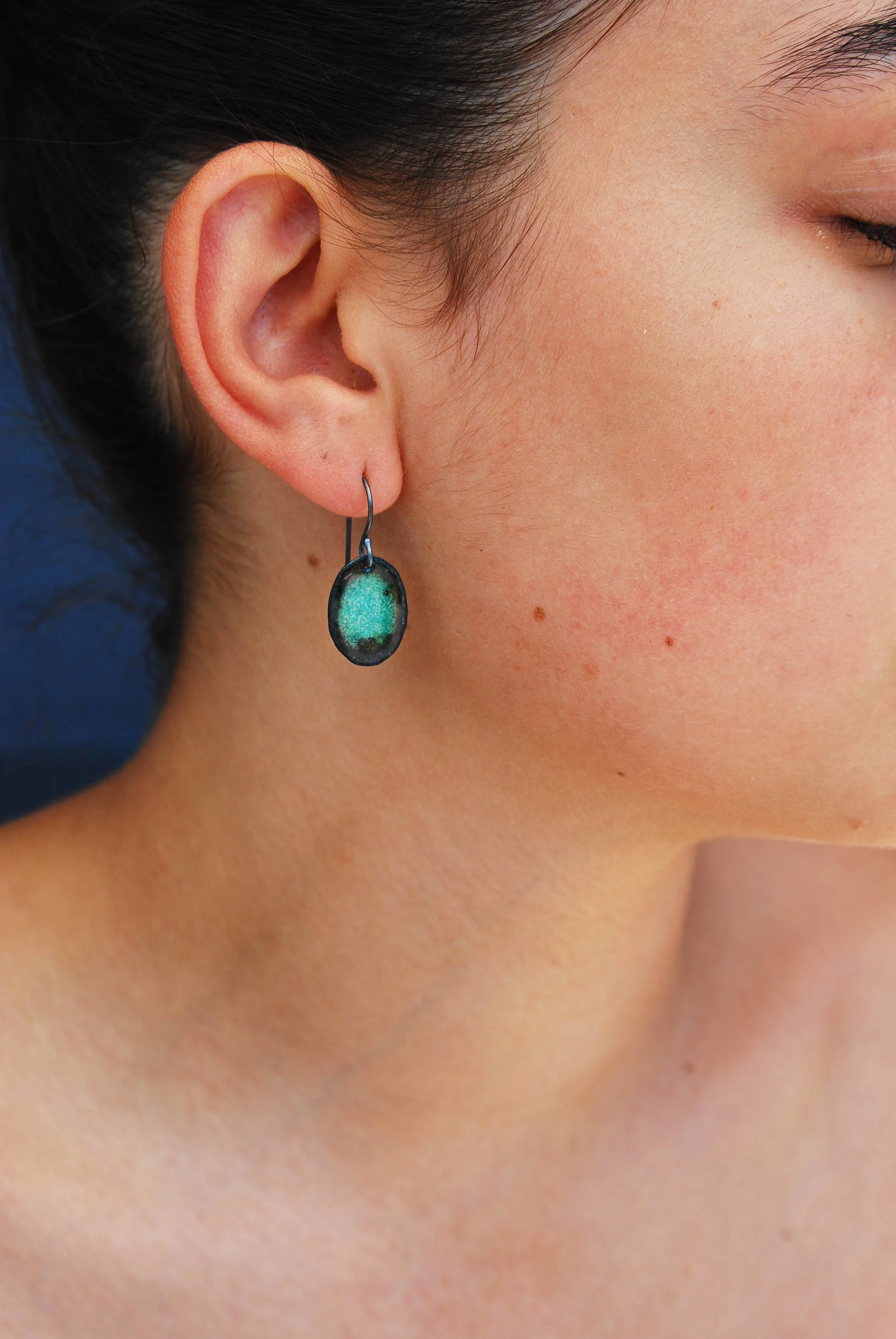 3/4" vitreous green/blue/teal enamel on textured copper dangle earrings with oxidized silver earwires on model