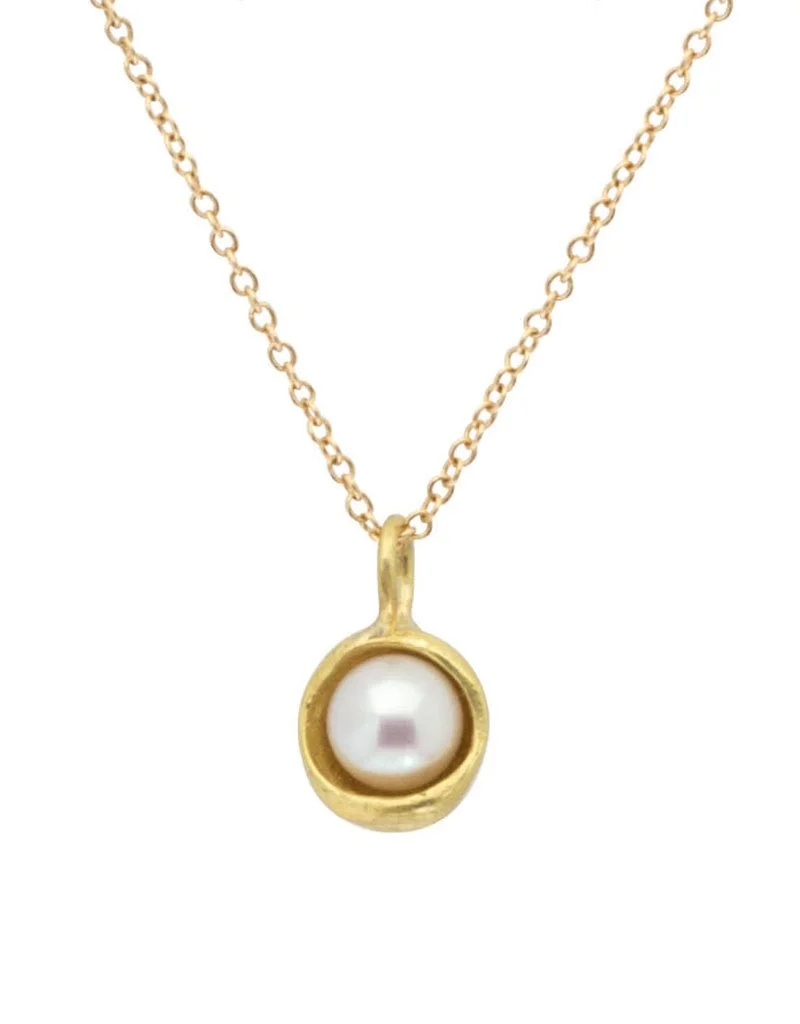 Gold chain necklace with a circular pendant containing a white pearl