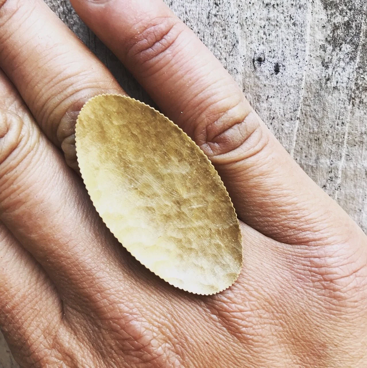 statement ring with serrated edge made from a rolled and hammered 22k gold coin