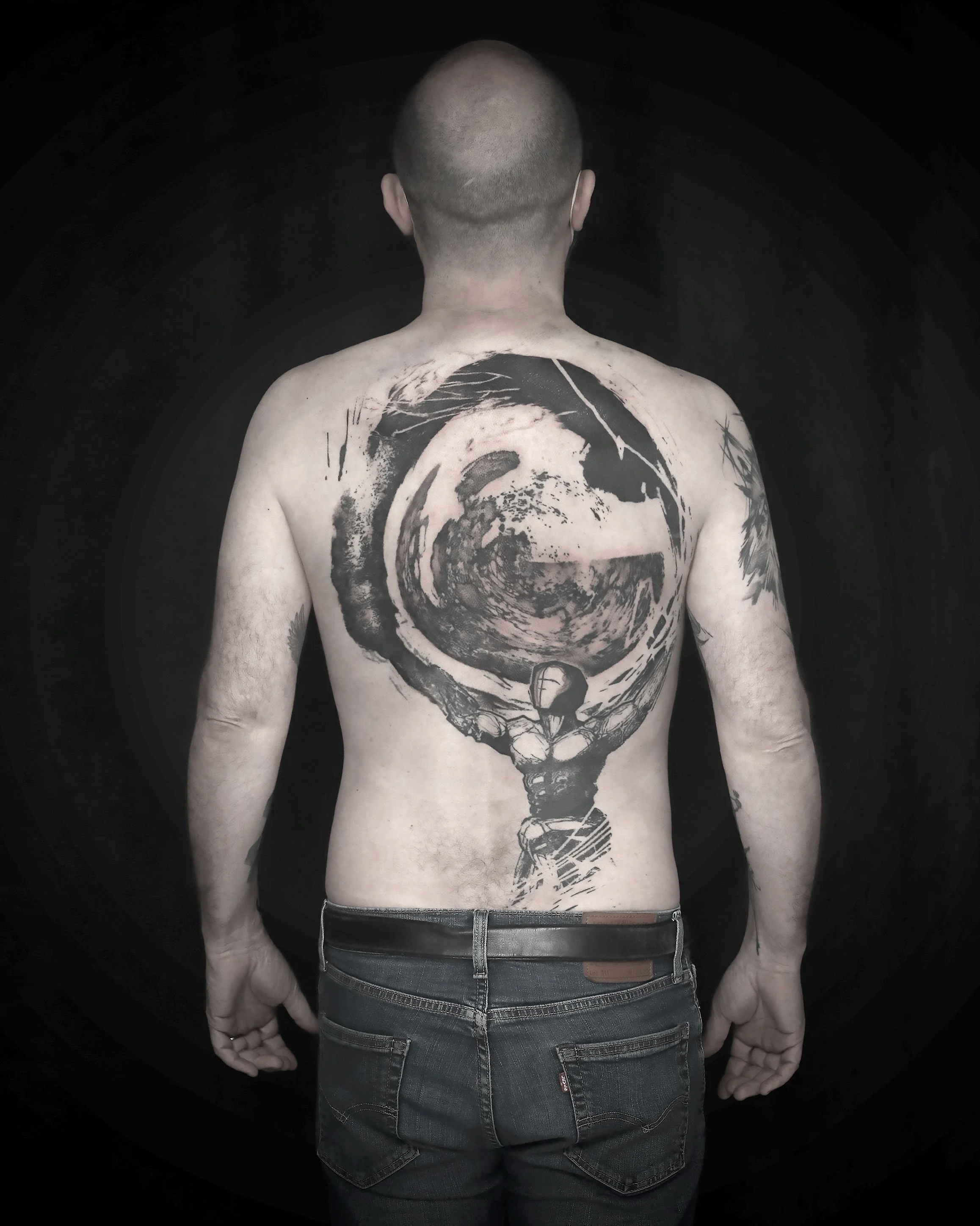 Le dos de Raphaël, un tatouage d'Atlas puissant qui ne subit pas le monde entier mais porte et assume fièrement de porter son monde. Un tatouage riches en textures.