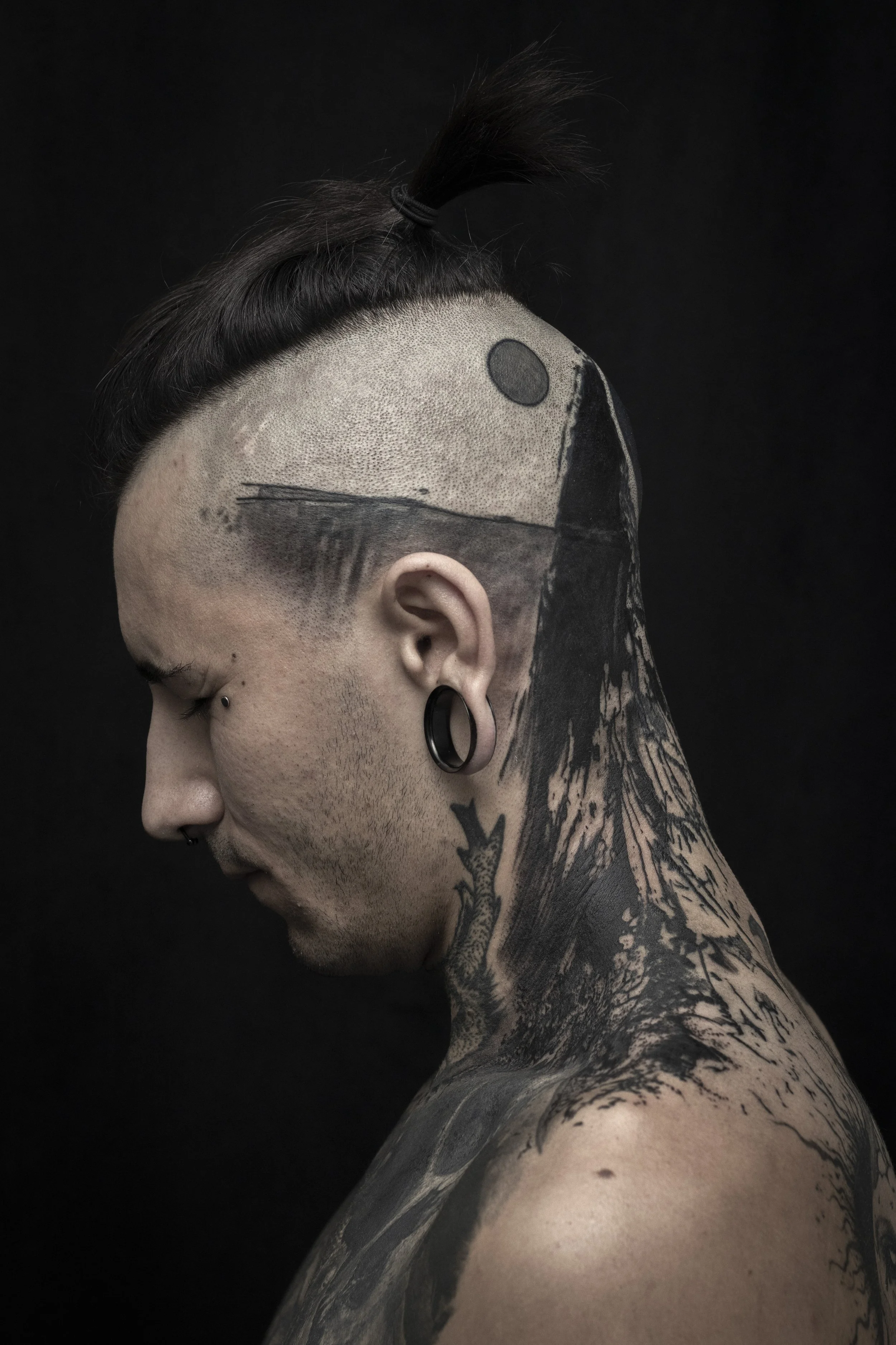 Composition abstraite et géométrique en teinte de noir. Un tatouage sur le crane fait à main levée.