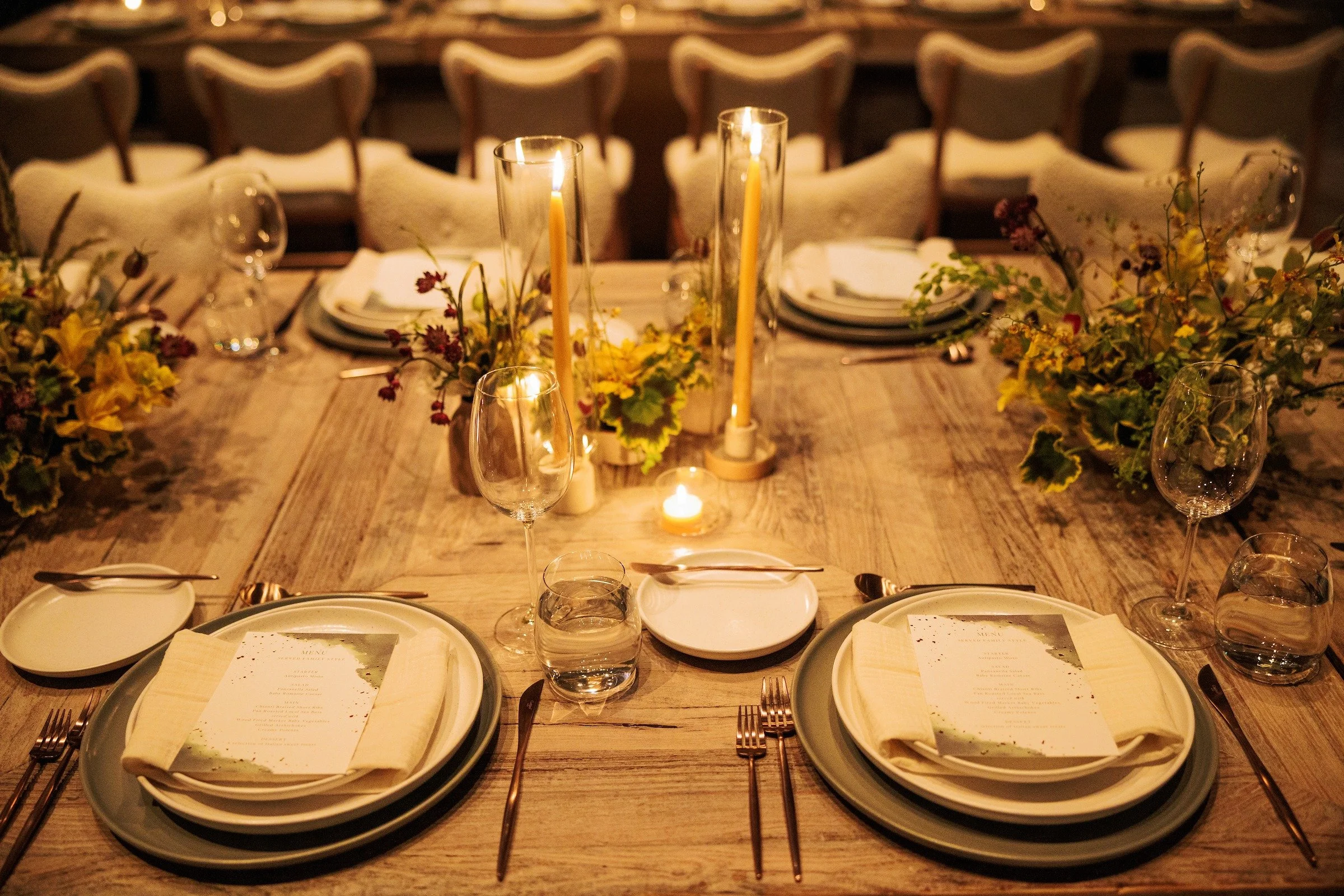Elegant candlelit dinner table setting with florals at luxury corporate event — Grove Projects