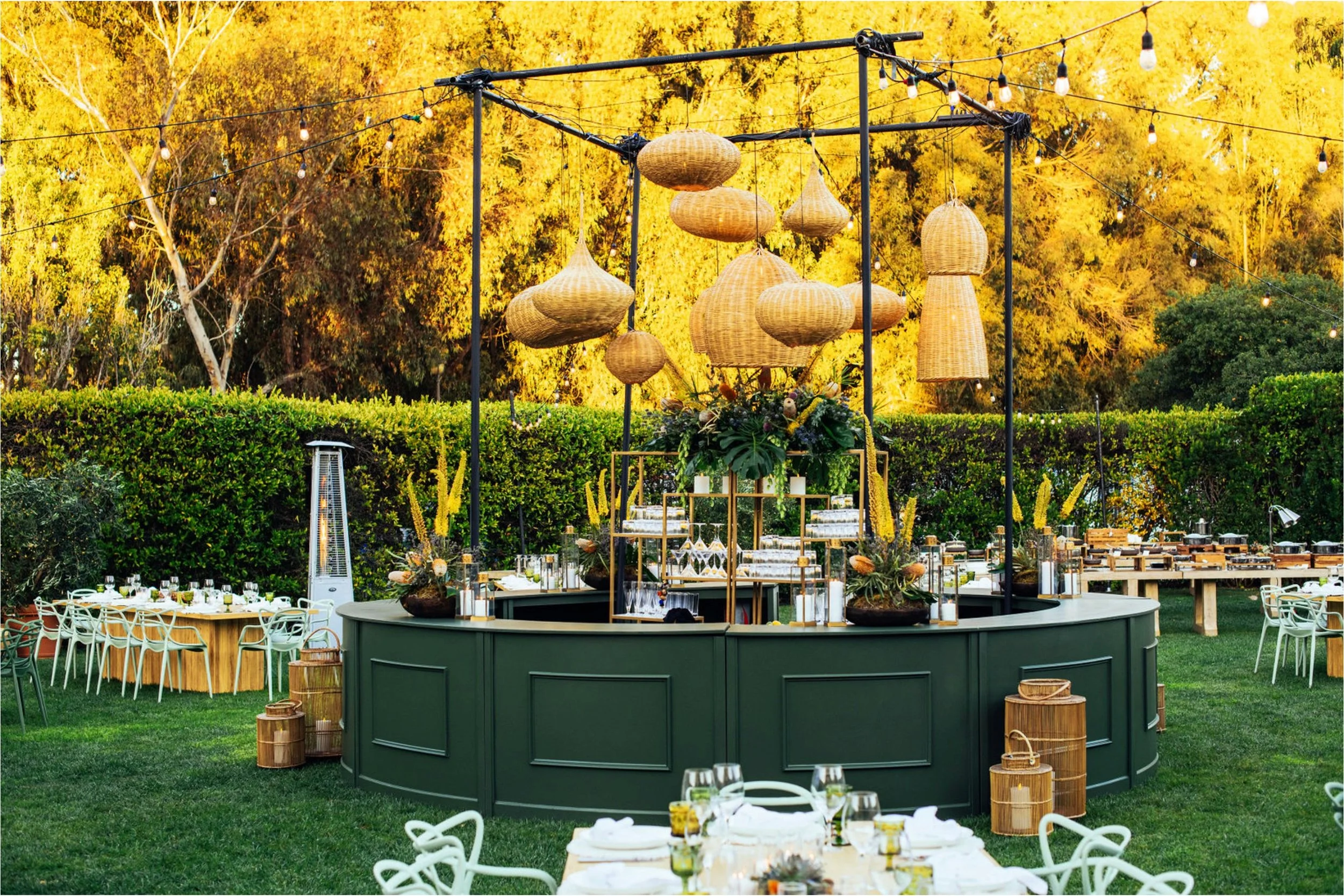 Outdoor luxury secret garden dinner with hanging lanterns and lush greenery — Grove Projects
